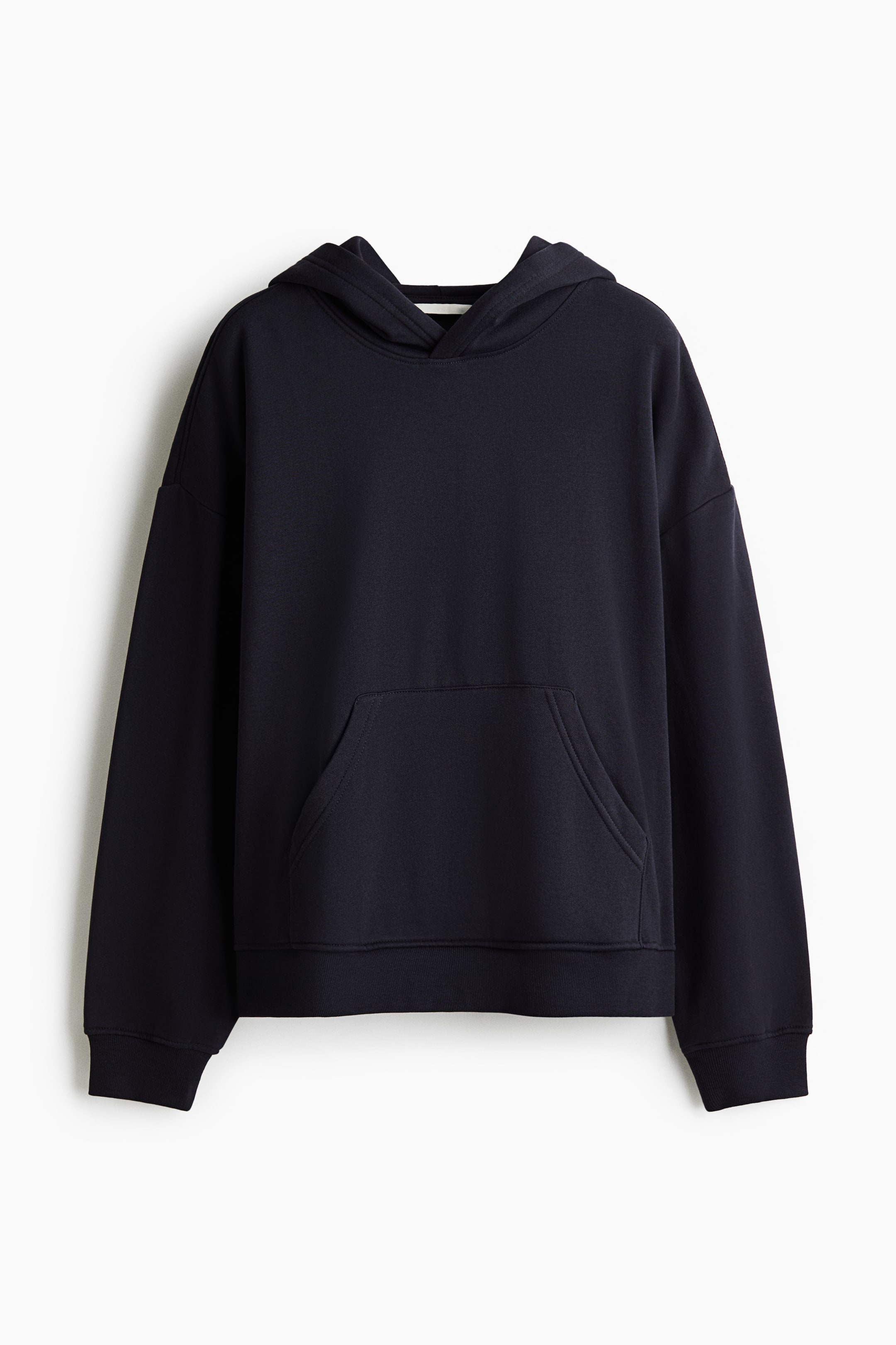 View larger image: A dark navy blue hoodie is hanging front-facing, featuring a double-layer hood, low dropped shoulders, and a front kangaroo pocket. The long sleeves end in ribbed cuffs, and the bottom hem is finished with matching ribbing.
