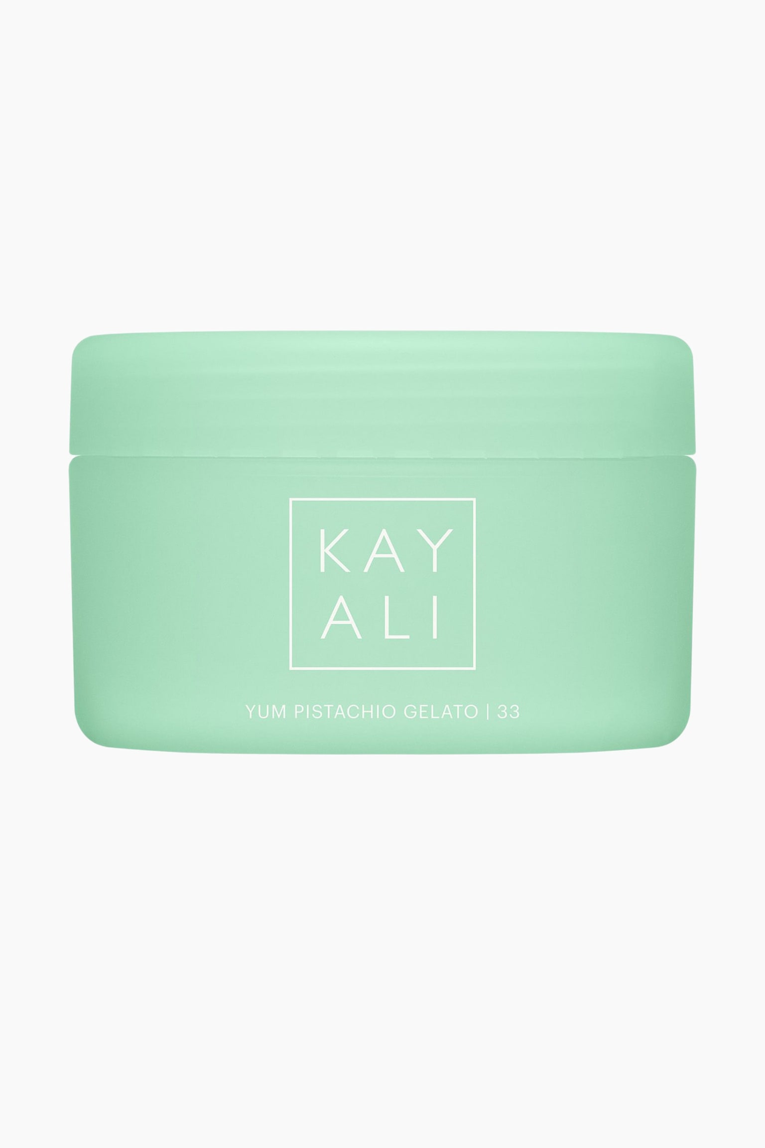 En framifrån-vy av kroppskrämen Kayali Yum Pistachio Gelato \| 33 visar en matt, mintgrön cylindrisk burk med ett matchande skruvlock. I mitten av burken finns Kayali-logotypen i vitt inuti en kvadrat, med produktnamnet tryckt i vitt nedanför. - 1