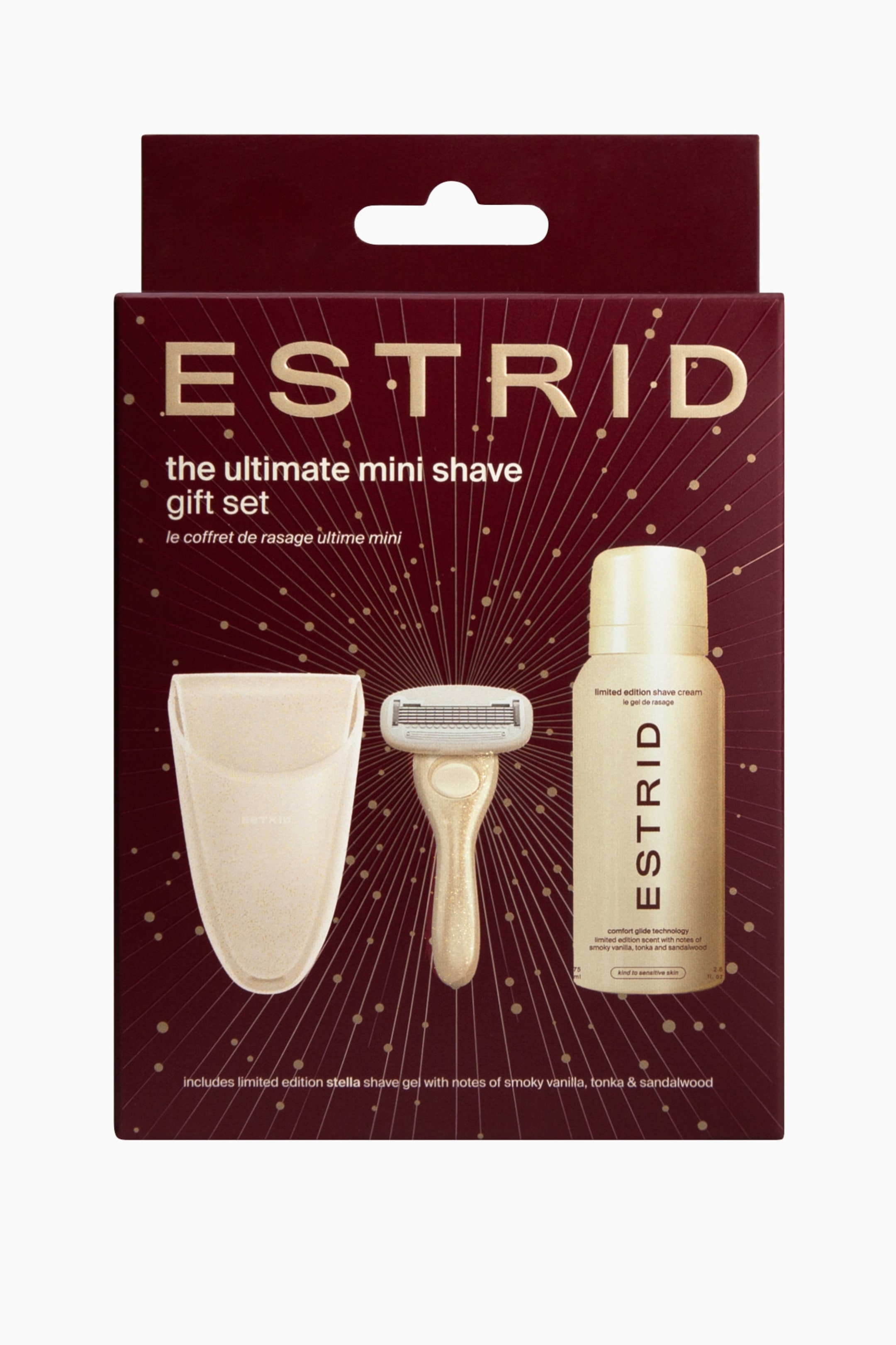 Se større billede: En gaveæske i bordeaux set forfra viser Estrids "the ultimate mini shave gift set" med guldfolietryk og strålende stjernedetaljer. Emballagen indeholder et lysebeige plettet rejseetui, en matchende mini barberkniv i funklende guld og en mini barbercremeflaske.