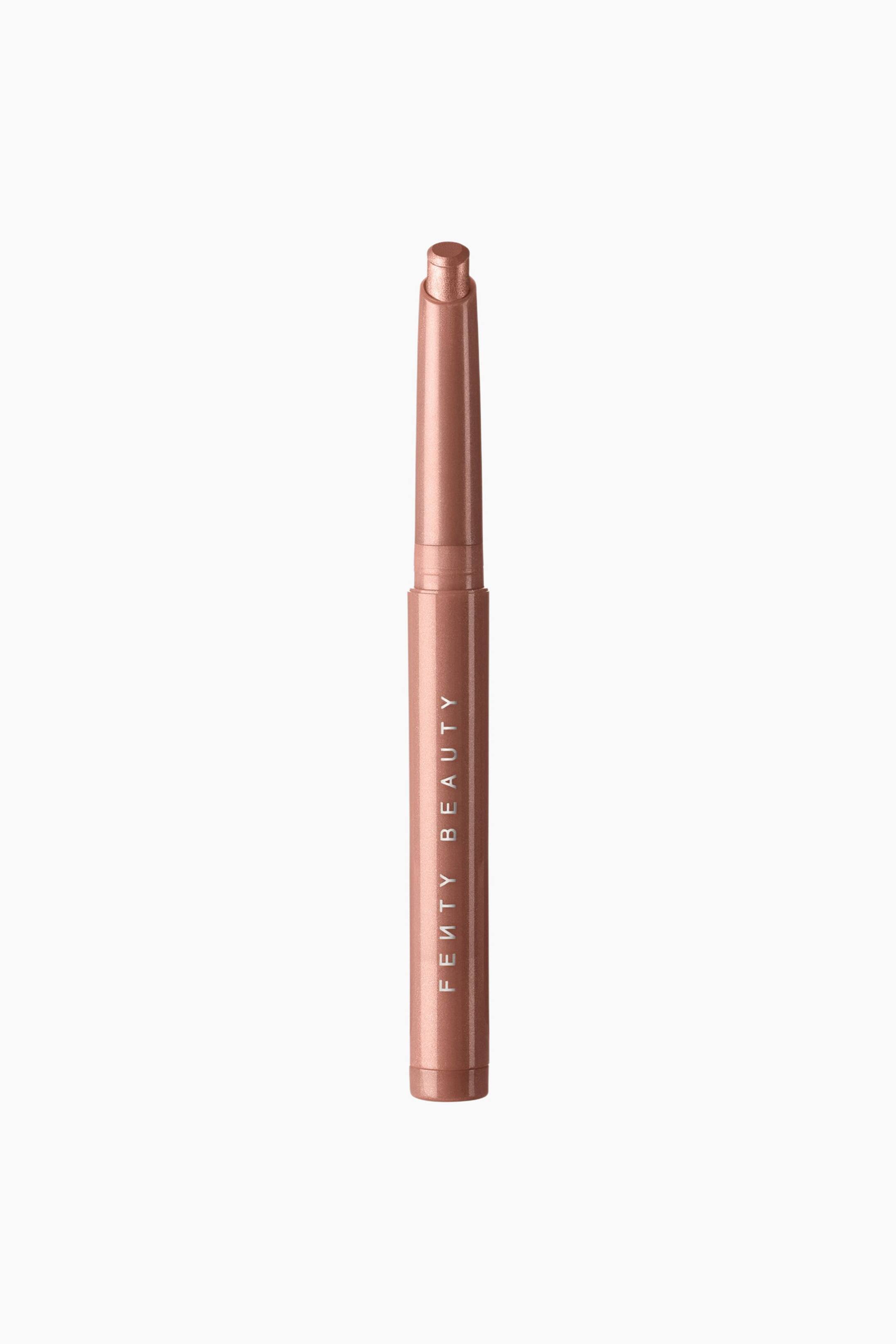 Se større billede: Shadowstix Longwear Eyeshadow Stick står lodret og fremviser sin slanke, cylindriske metalliske rosaguld-indpakning med brandnavnet trykt lodret i hvidt. Den skinnende rosaguldfarvede cremeøjenskygge er skubbet frem fra toppen og viser sin flade, skrå spids.