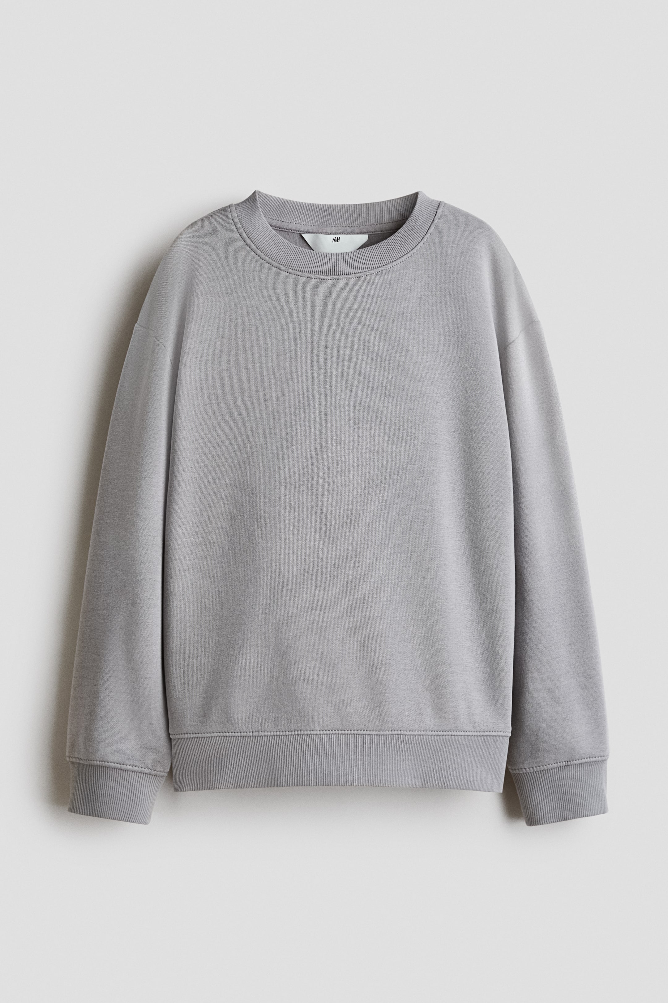 Agrandir l'image: Un pull gris est présenté de face, avec un col rond bord-côte, des épaules tombantes, des manches longues, des poignets côtelés et un ourlet côtelé.