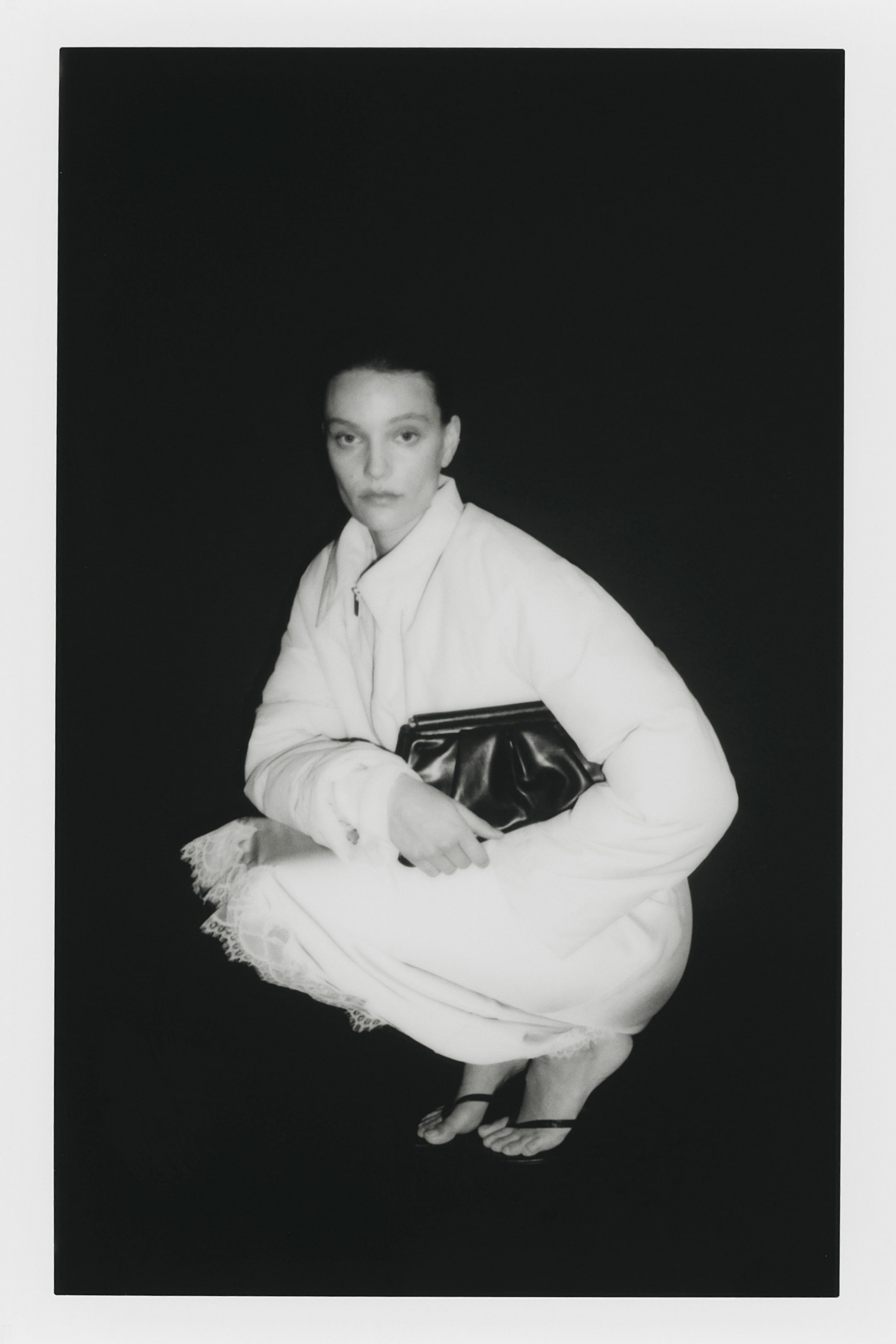 הצגת תמונה גדולה יותר: החצאית באורך אמצע השוק מציגה בד ארוג בצבע בהיר עם ברק קל, מסיימת עם שולי חיתוך ישר ותחרה מעוטרת בגלים.