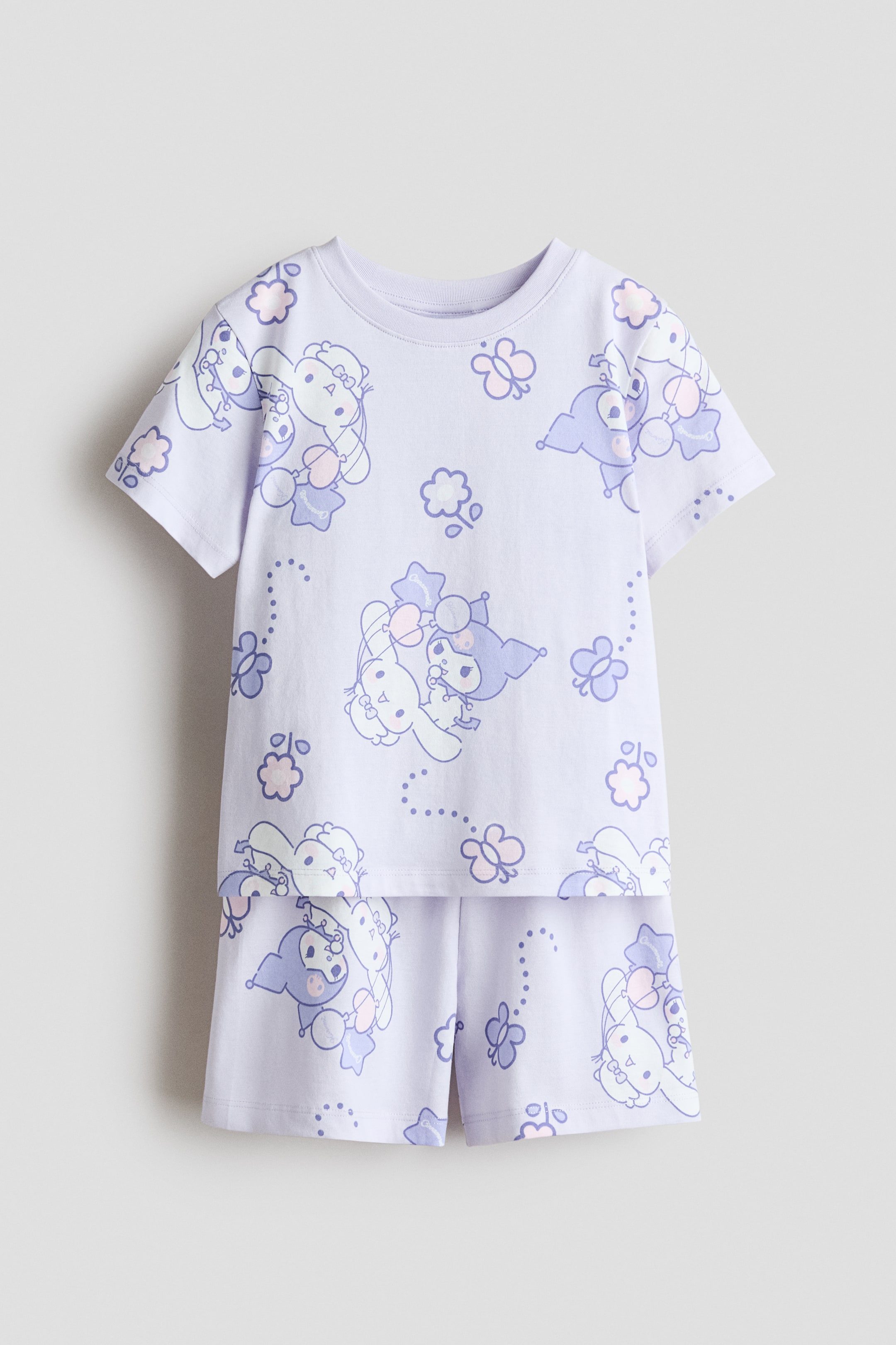 View larger image: Pyjamas set comprising a t-shirt and shorts in a light purple printed cotton jersey, displayed front-facing, decorated with an all-over print of cartoon characters, butterflies, and dotted lines. The t-shirt showcases a round, ribbed neckline and a straight hem, while the shorts feature an elasticated waistband.
