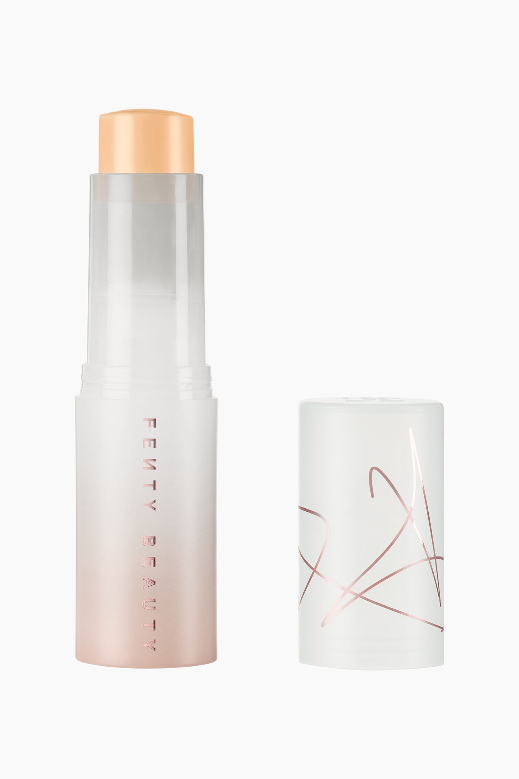 Visa större bild: Eaze Drop Blur + Smooth Tint Stick står upprätt och visar en fast, ljus persikofärgad makeupformula som är utdragen ur en frostad, halvtransparent hylsa med en rosa-till-vit gradient och vertikal ”FENTY BEAUTY”-text. Ett matchande cylindriskt lock står till höger och har abstrakta, tunna linjer i roséguld som löper runt dess frostade vita yta.