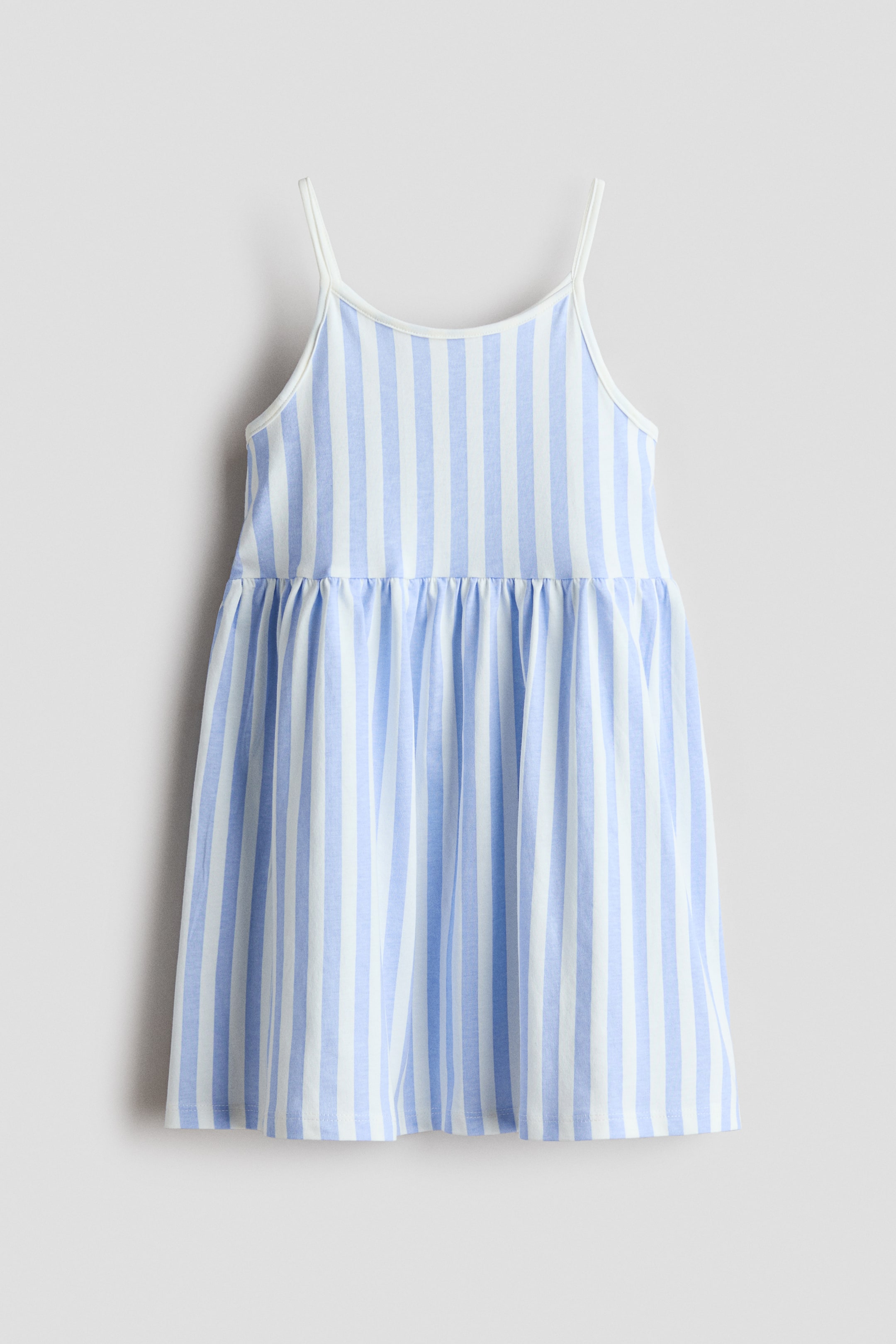 Agrandir l'image: Une robe face avant présente des rayures verticales bleu clair et blanches, avec de fines bretelles blanches et un décolleté arrondi orné d'un fin liseré blanc. Une couture froncée définit la taille, d'où s'étend une jupe légèrement évasée.