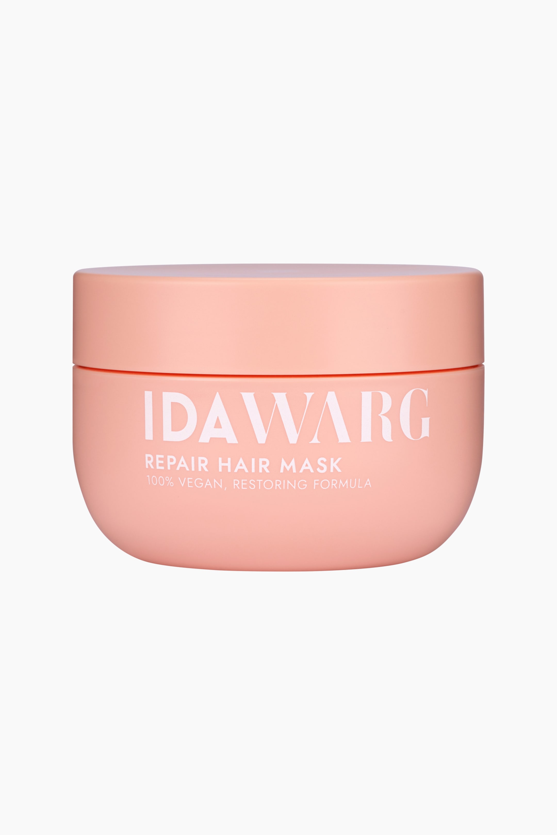 Visa större bild: En persikofärgad burk med hårmask står rakt framåt, med en rundad kropp och ett platt lock. Vit text med "IDAWARG REPAIR HAIR MASK" och "100% VEGAN, RESTORING FORMULA" är tryckt på framsidan.