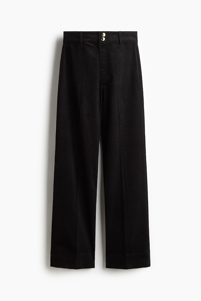 Black corduroy trousers are being presented from the FRONT, featuring a high waist with a zip fly and two gold-colored buttons, and showing straight legs with a visible crease running down the front of each leg. - 1
