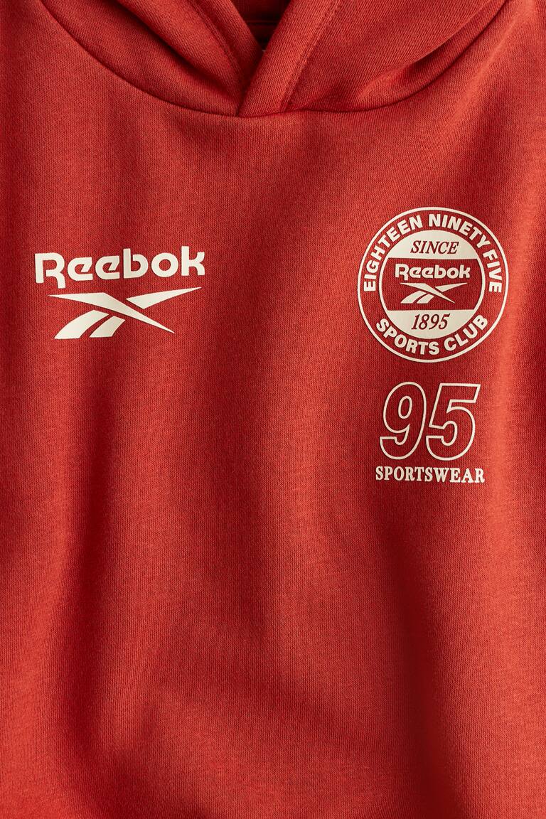 Felpa con cappuccio e motivo stampato Rosso/Reebok BAMBINO