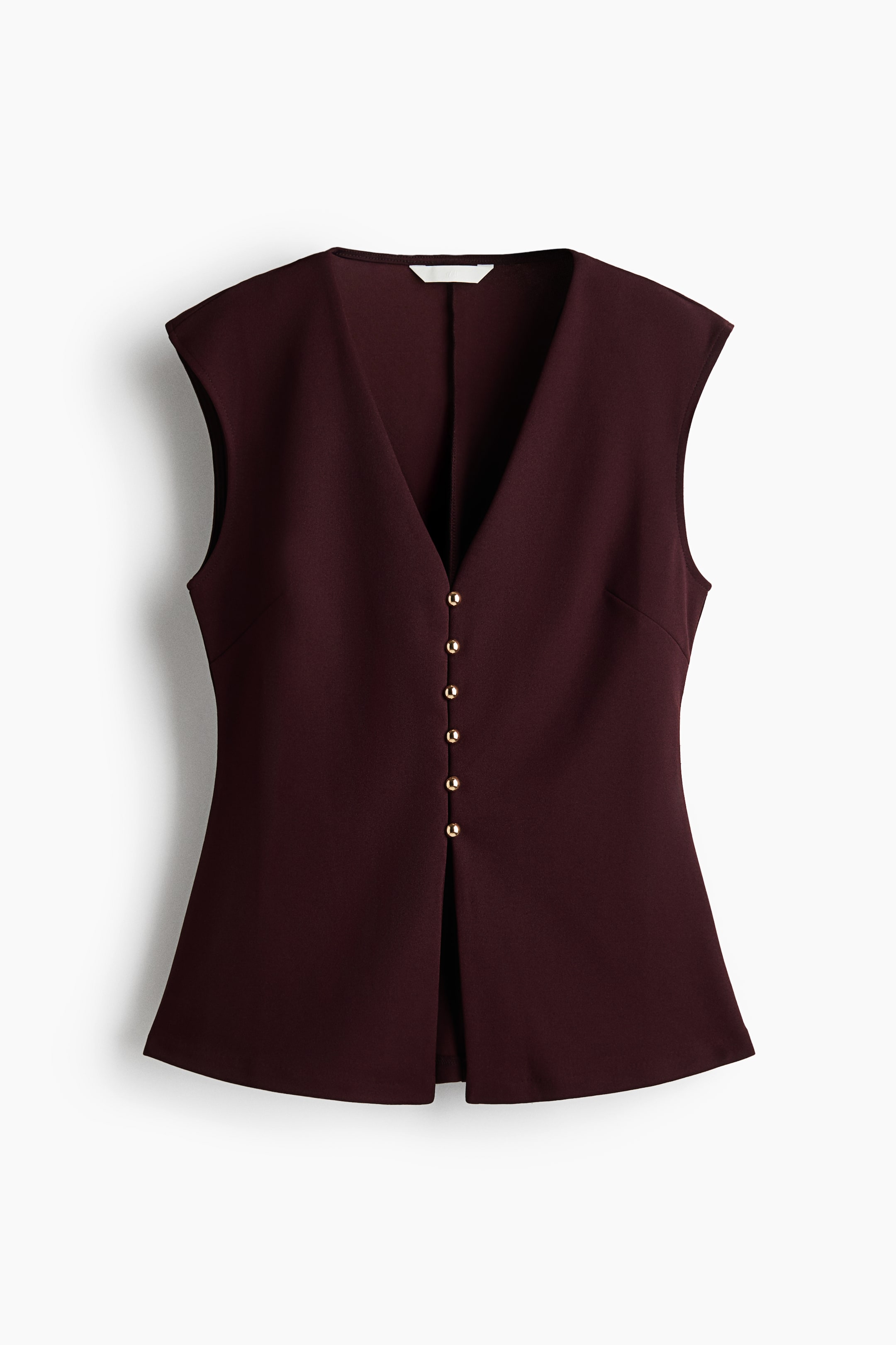 View larger image: A dark burgundy sleeveless tailored top is shown front-facing, featuring a deep V-neckline and a fitted, structured silhouette. The top features a central front closure with six small, round gold buttons and a slightly flared hem with a split detail at the centre bottom.