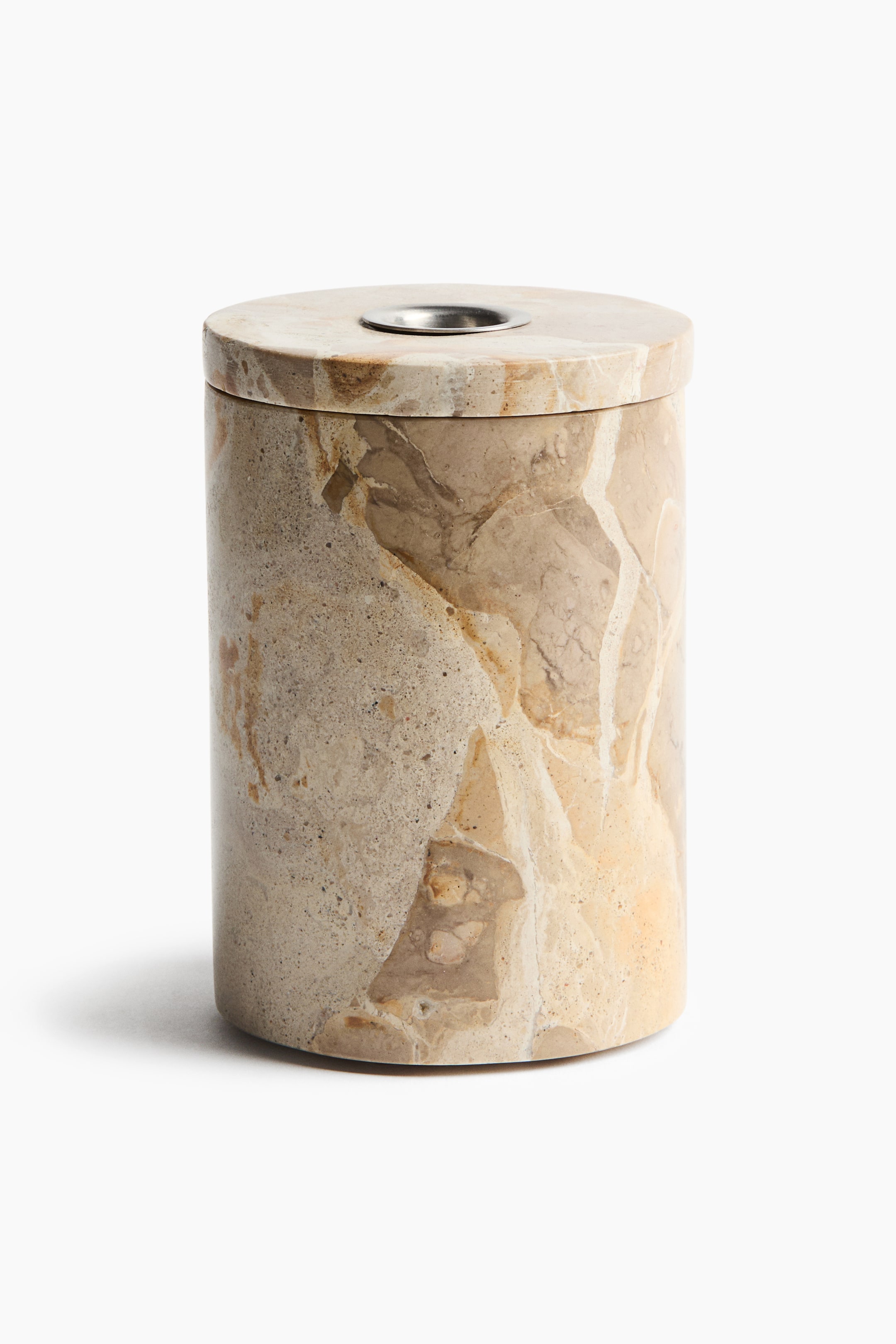 View larger image: A cylindrical beige marble canister stands upright, displaying natural tan and cream veining. A matching flat marble lid rests on top, featuring a circular silver-toned metal opening in the centre.