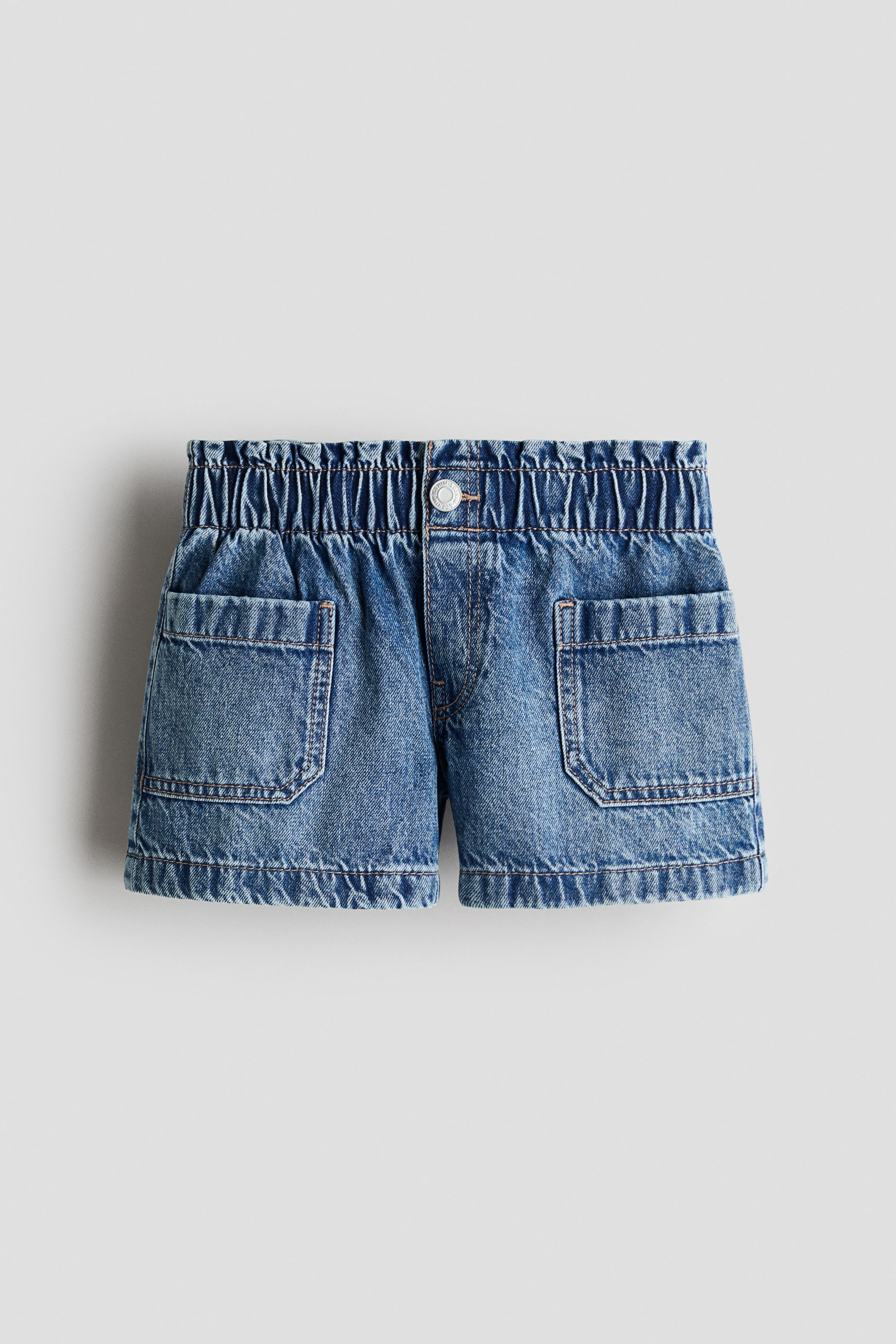 View larger image: The FRONT of loose-fit shorts in washed cotton denim features an elasticated paper bag waist, a fake fly with a press-stud, and two large patch pockets.