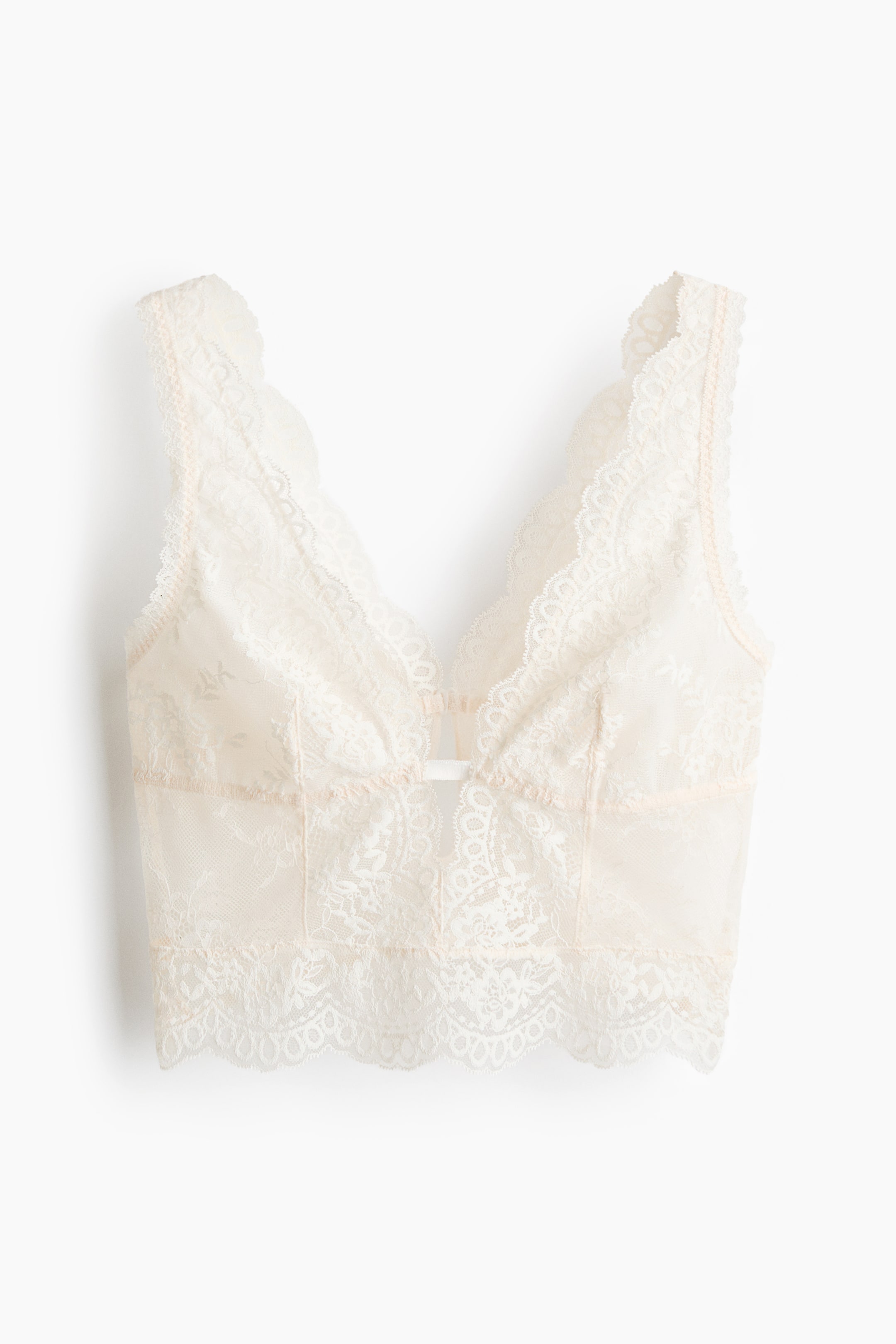 View larger image: The bralette, displayed front-on, showcases cream-coloured lace with a plunging V-neckline, mesh-lined cups that offer a natural shape and light support, and a petite keyhole opening at the centre front.