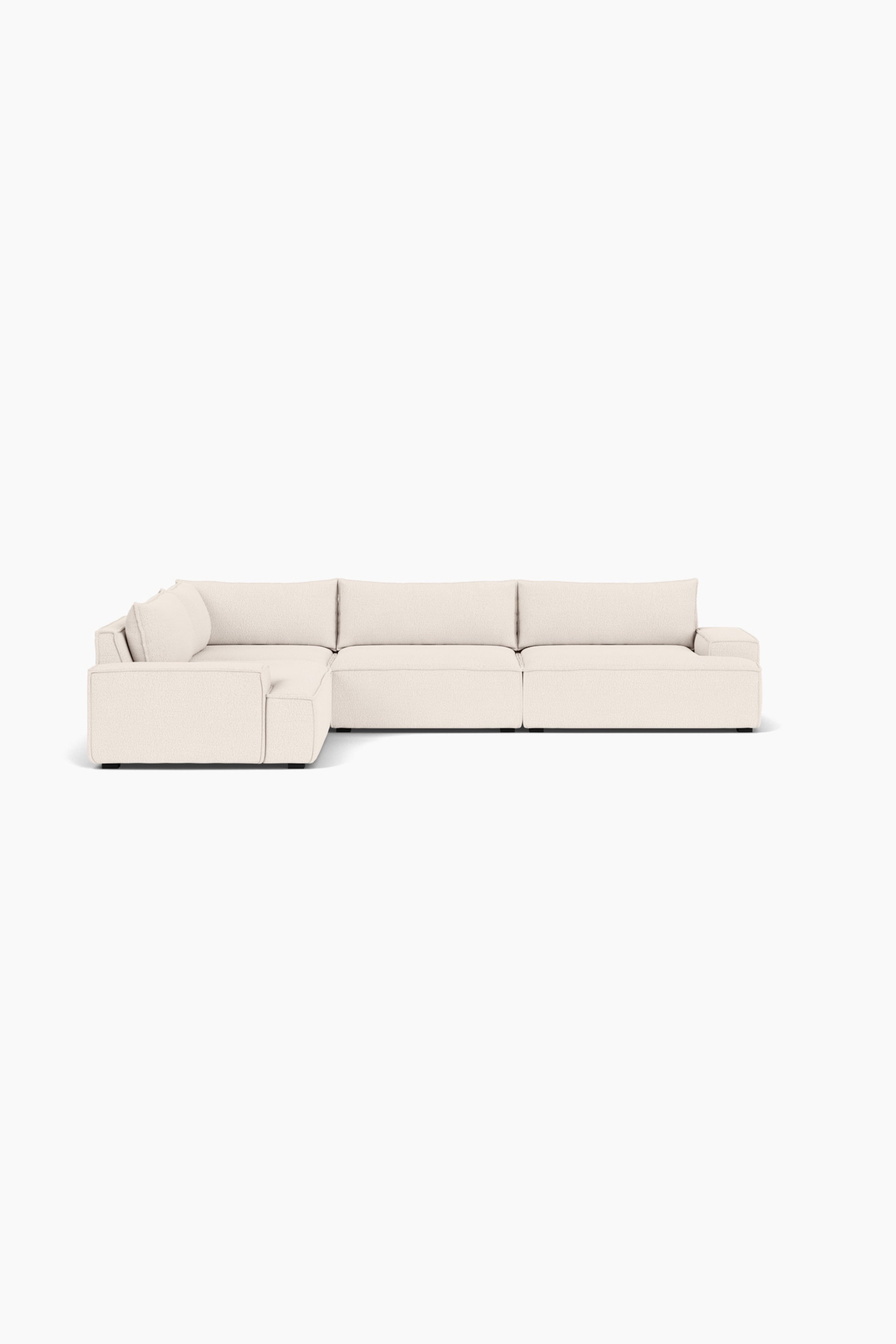 Größeres Bild ansehen: Ein L-förmiges modulares Ecksofa, bezogen mit einem strukturierten cremefarbenen Stoff, ist nach vorne und leicht nach rechts ausgerichtet und zeigt seine linksseitige Eckkonfiguration. Das Sofa präsentiert eine flache Silhouette mit tiefen, blockigen Sitzkissen, weichen Rückenkissen und breiten, kantigen Armlehnen.