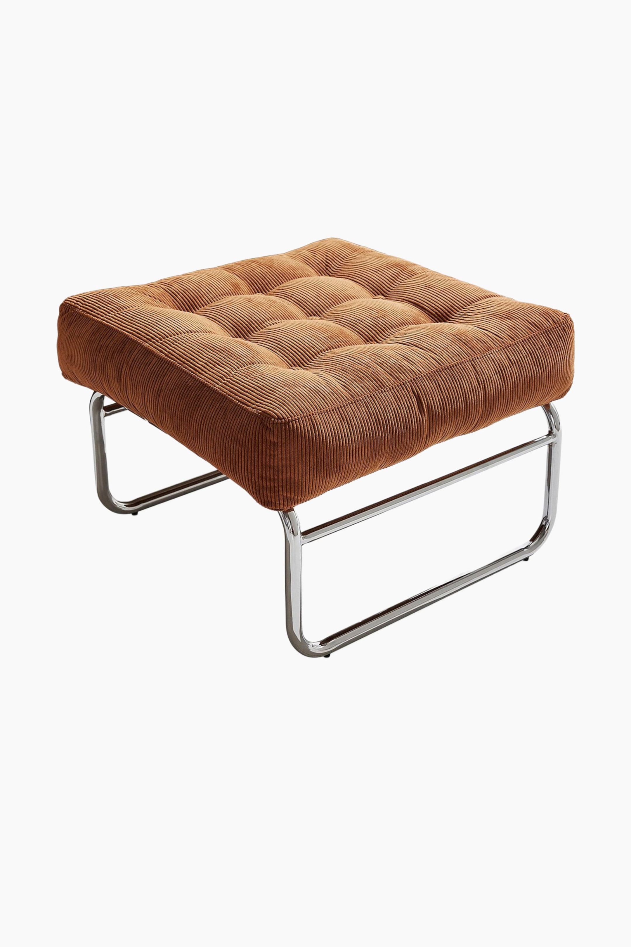 Grotere afbeelding bekijken: Een poef heeft een vierkant, gecapitonneerd kussen, bekleed met geribbelde bruine corduroy. Het kussen rust op een gepolijst chromen sleebasis, die zichtbaar is vanuit een front-rechts, licht verhoogde hoek, waarbij de U-vormige ondersteuningsstructuur zichtbaar wordt.