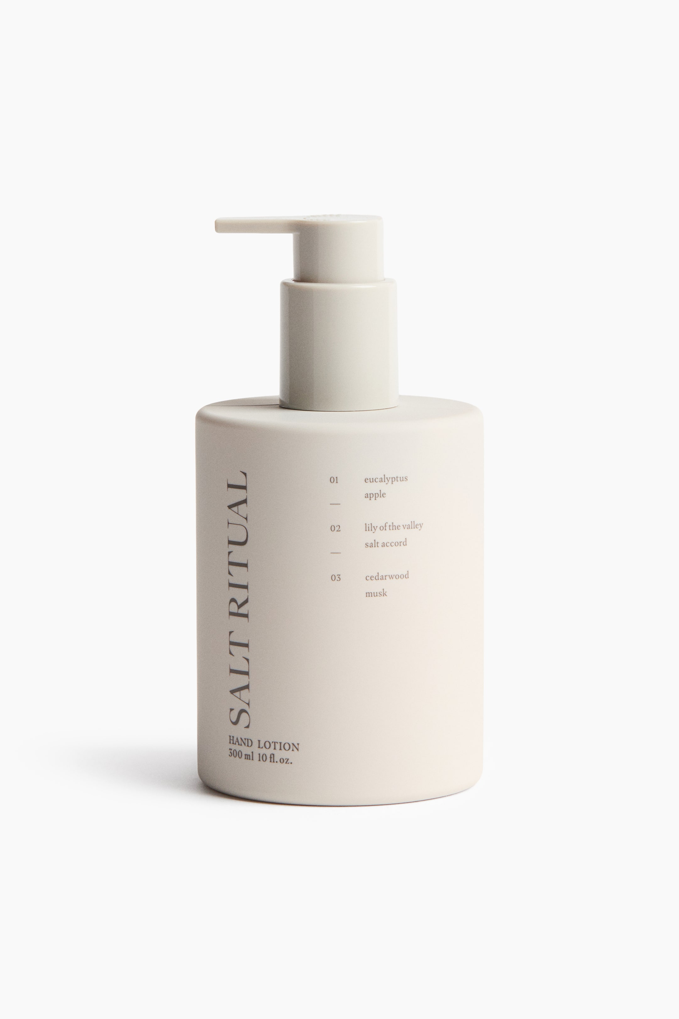 View larger image: A light beige hand lotion bottle is facing front, featuring a matching pump dispenser top. The bottle displays 'Salt Ritual' vertically on its left side, with 'hand lotion 300 ml 10 fl.oz.' horizontally below it, and three numbered scent descriptions on the right.