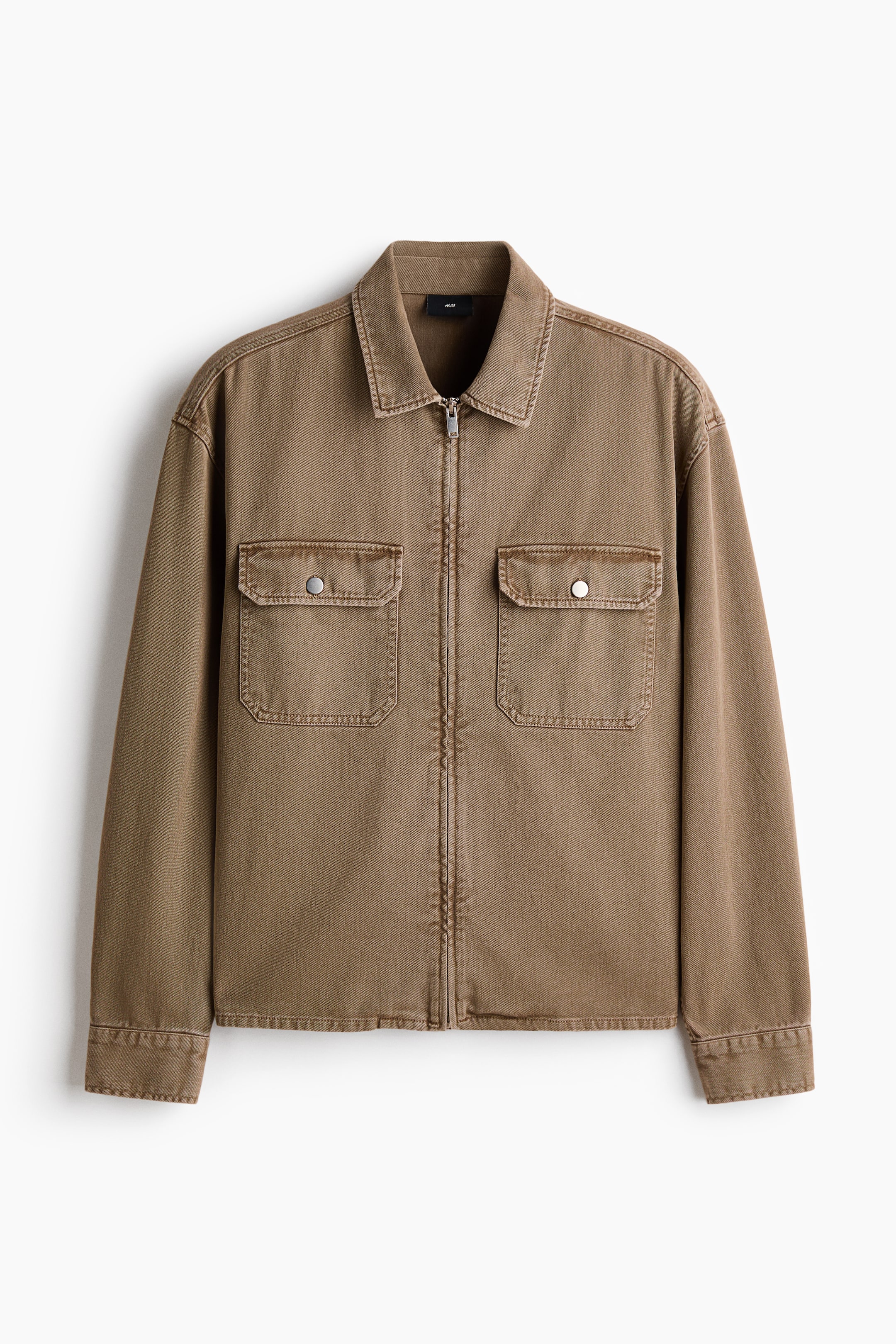 View larger image: A washed brown cotton twill jacket is facing front, featuring a pointed collar, a full-length silver-toned zip fastening, and two chest flap pockets with silver-toned snap-button closures.