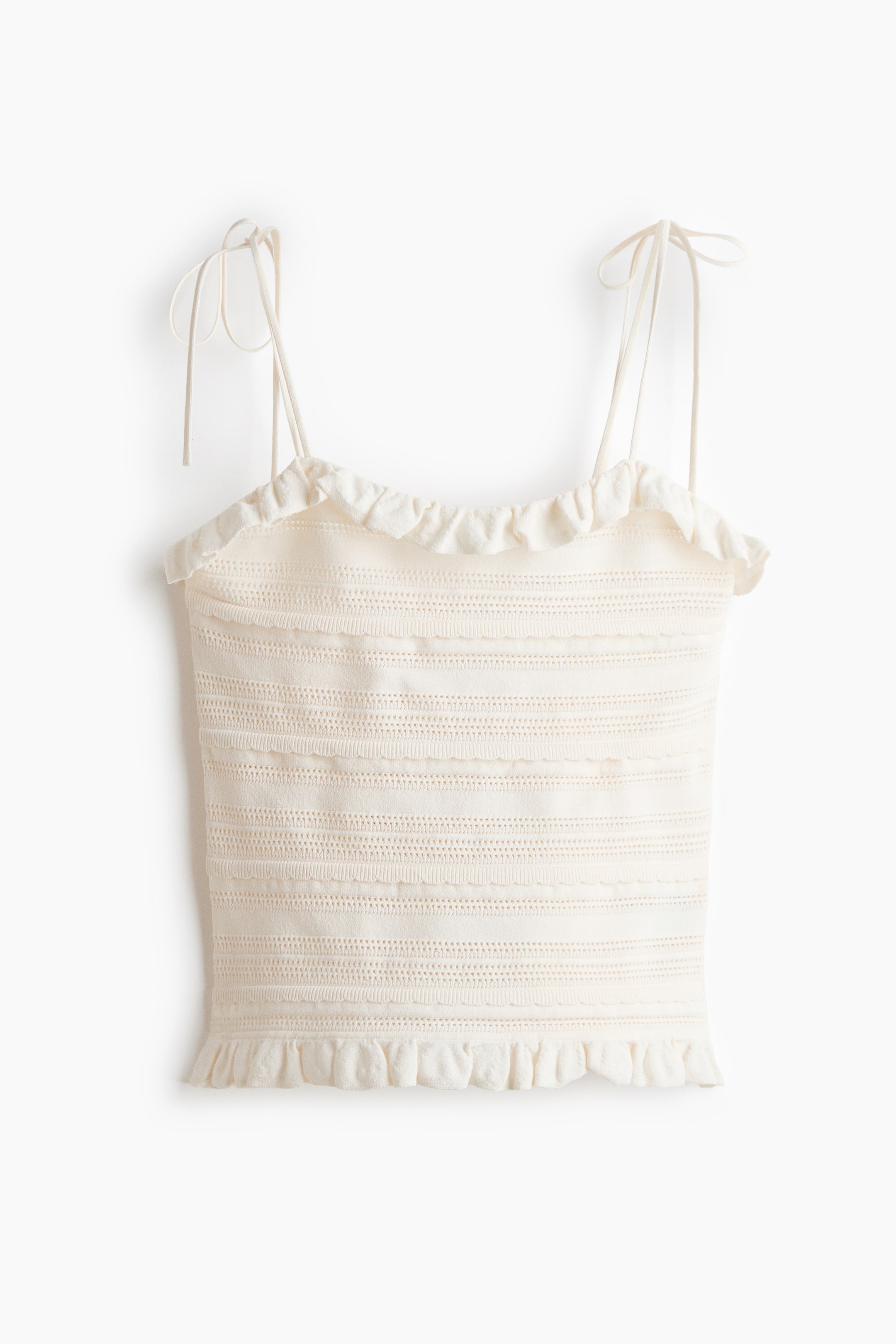 Ver imagen más grande: Un camisole de punto crema se presenta en vista frontal con finos tirantes ajustables y un escote con volantes. El cuerpo presenta bandas horizontales de texturas caladas variadas y un dobladillo con volantes.