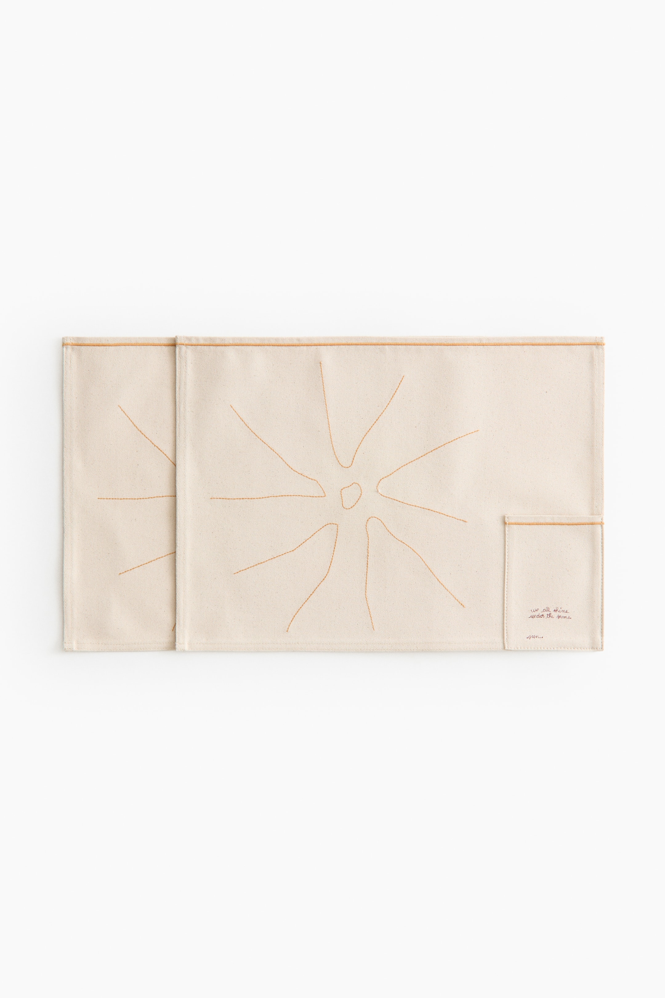Agrandir l'image: Deux pièces textiles rectangulaires de couleur crème présentent un motif abstrait rayonnant en couture marron clair sur leur surface avant. La pièce de droite comporte une petite poche cousue dans son coin inférieur droit, contenant un texte en style manuscrit.