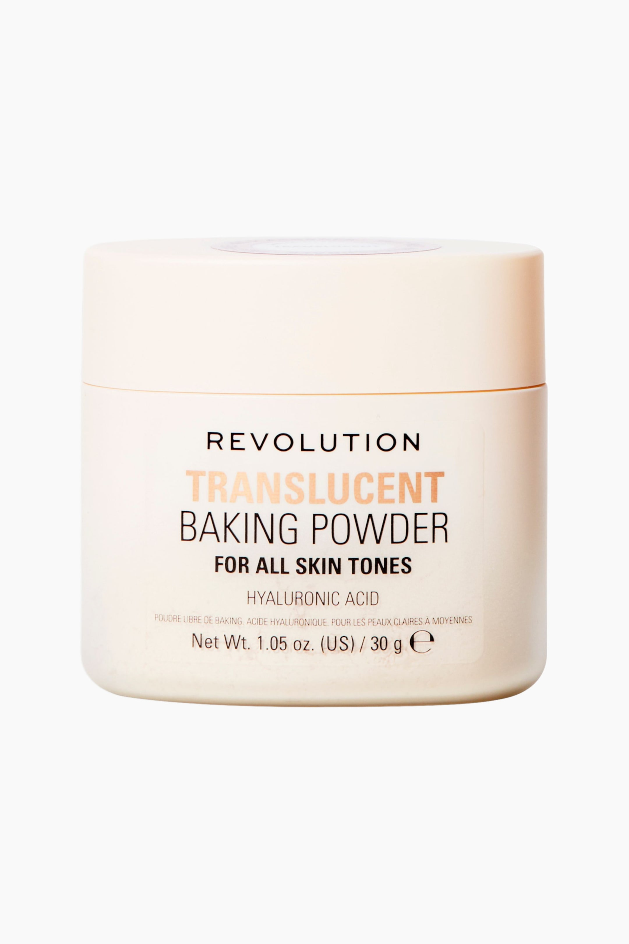 Visa större bild: En krämfärgad cylindrisk burk med Revolution Translucent Baking Powder står upprätt och vänd direkt framåt. Behållaren har ett matchande skruvlock och visar svart och metalliskt persikofärgad text på sin framsidesetikett.