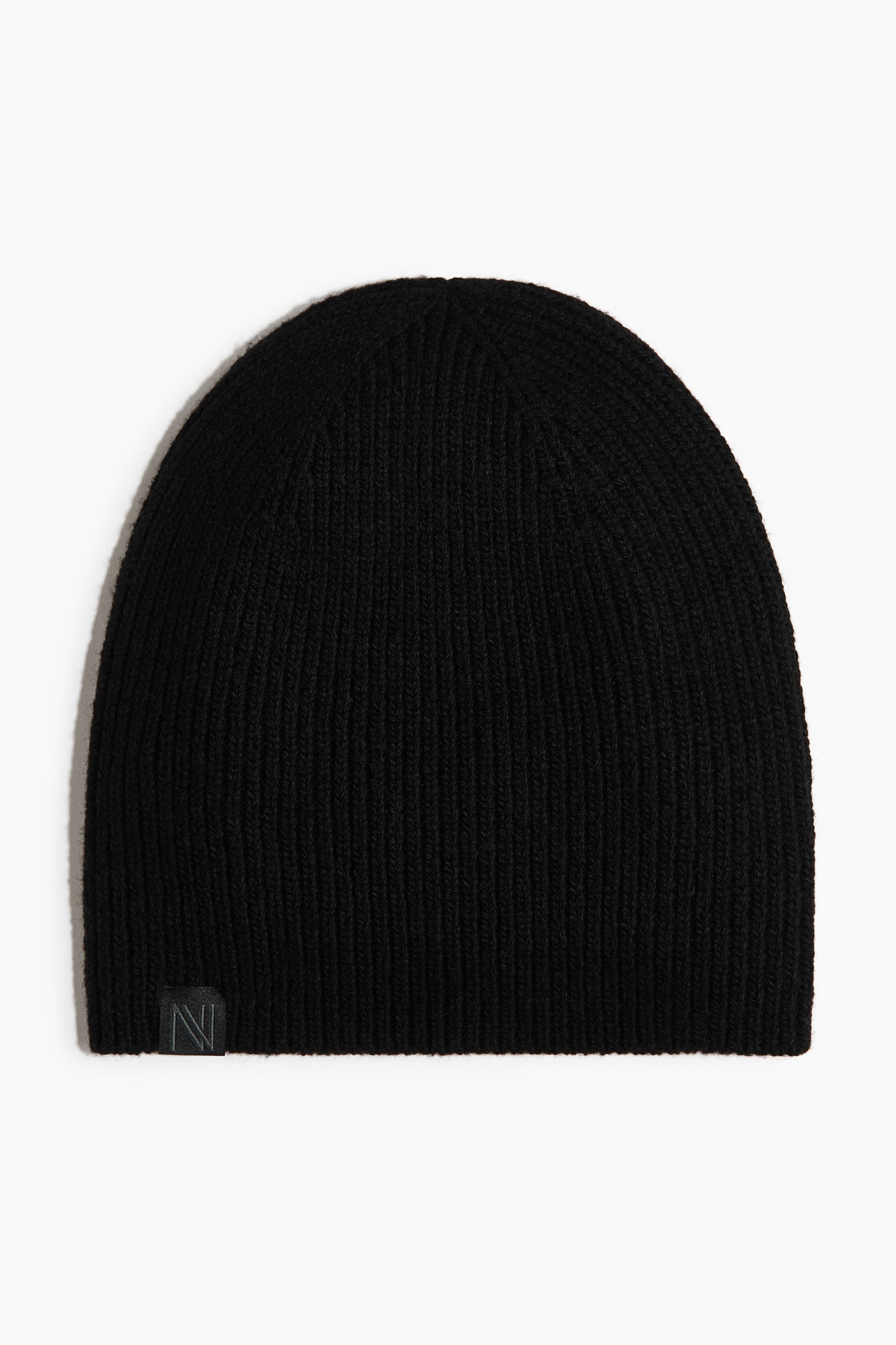 View larger image: A black beanie featuring a ribbed knit pattern, visible from the front. A small, dark rectangular woven label with a stylized capital N appears on its lower left side.