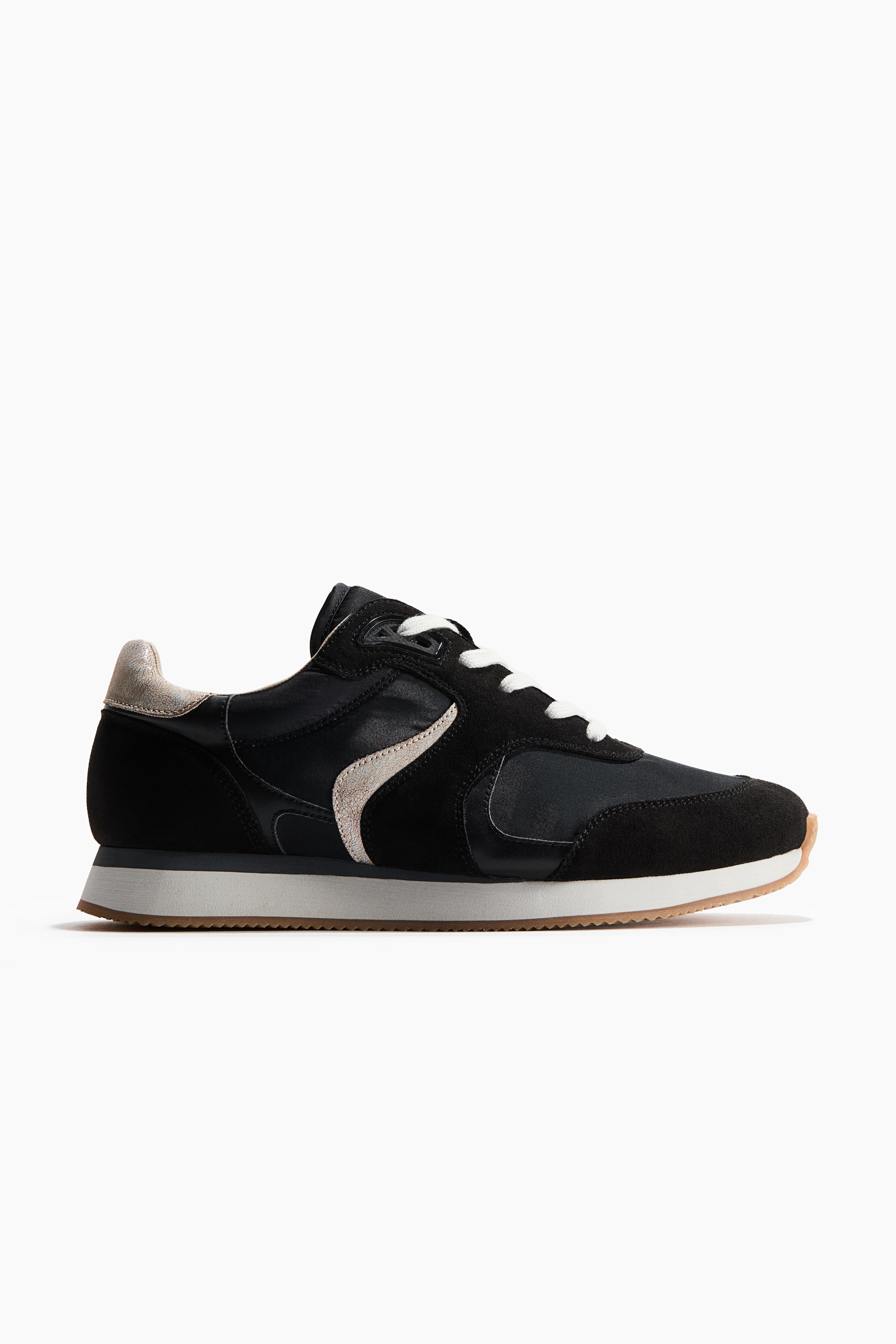 Visualizza immagine più grande: Una sneaker presenta una tomaia nera, combinando sovrapposizioni in suede sulla punta, sul tallone e sugli occhielli con pannelli in nylon sui lati. È caratterizzata da un elemento di design ondulato e testurizzato in beige chiaro sul lato e un linguetta del tallone coordinata, lacci bianchi, un'intersuola stratificata bianca e grigia, e una suola in gomma, il tutto mostrato da una vista laterale.