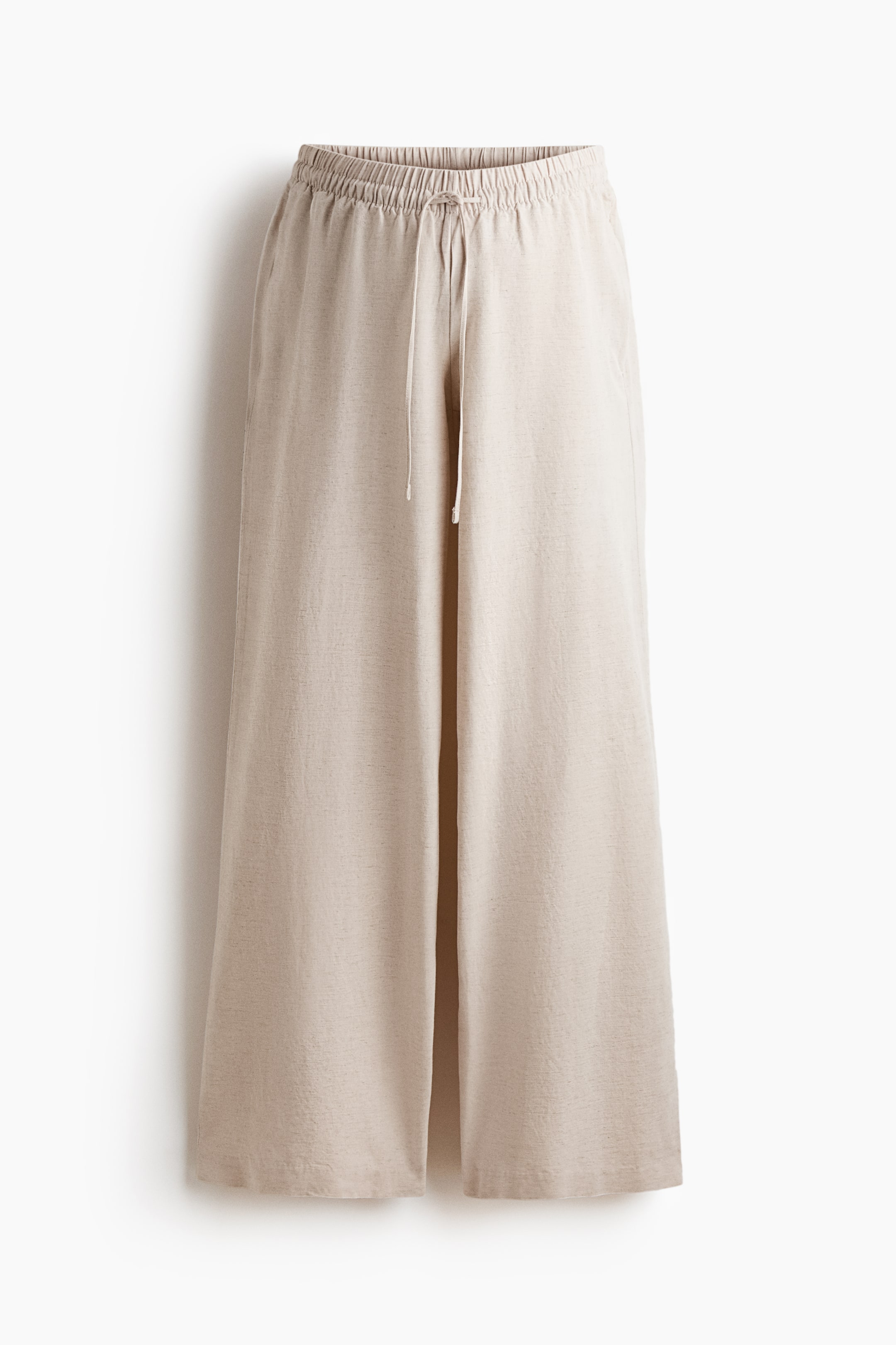 Grösseres Bild ansehen: Hellbeige, locker sitzende Hosen präsentieren sich von vorne und verfügen über einen gerafften, elastischen Bund mit einer schmalen Kordel, die vorne gebunden ist. Sie zeigen dezente Seitentaschen und weite, gerade Beine und sind aus einem luftigen, strukturierten Gewebe gefertigt.
