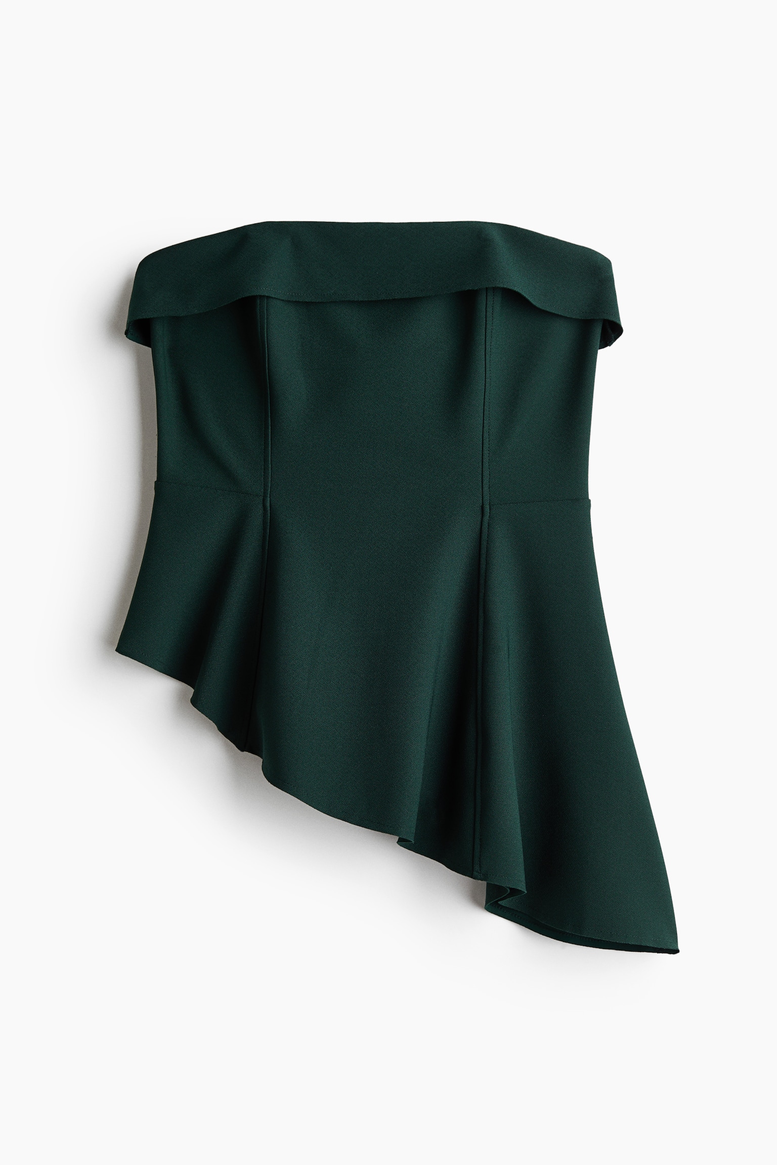 A dark green strapless top is facing front, showcasing a structured bodice with a wide fold-over neckline and vertical seams. The bodice transitions into a draped, asymmetrical peplum hemline that cascades longer on one side.