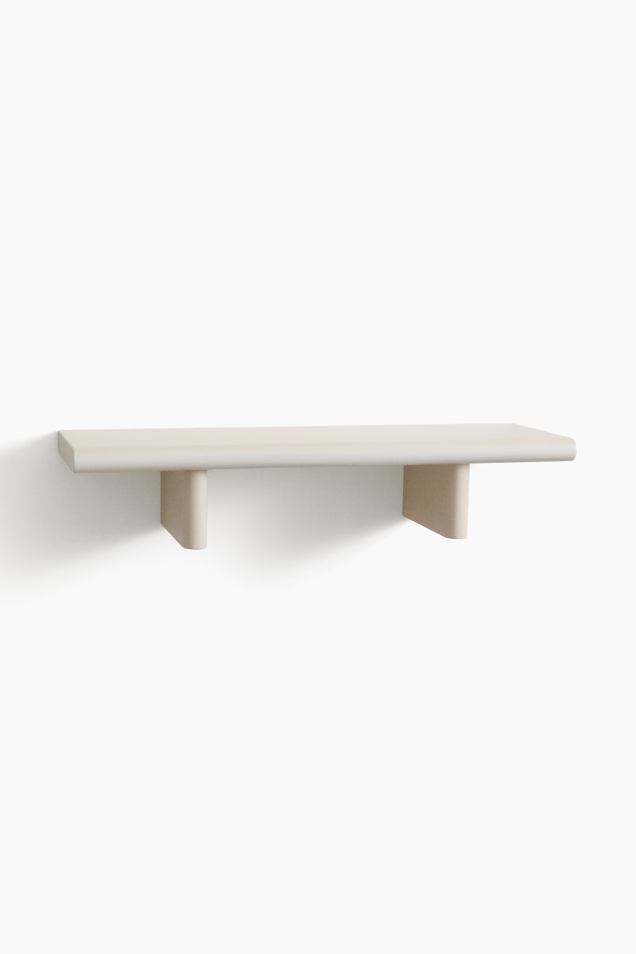 View larger image: A light-toned shelf extends horizontally, showcasing a long, rectangular top surface with two integrated, block-like supports beneath. The shelf and its supports boast softened, rounded edges.