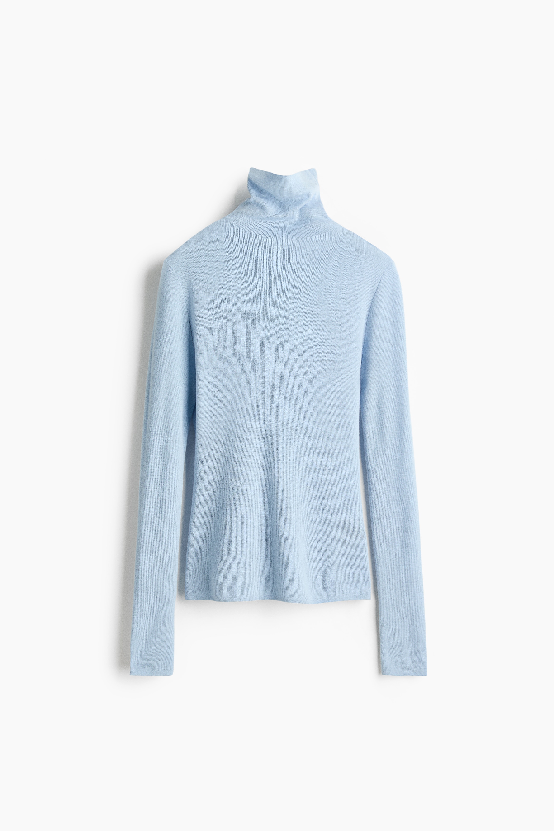 The model is wearing a light blue, fine-knit turtleneck sweater. The sweater features a fitted turtleneck collar and a soft, lightweight texture with a gently dropped shoulder.