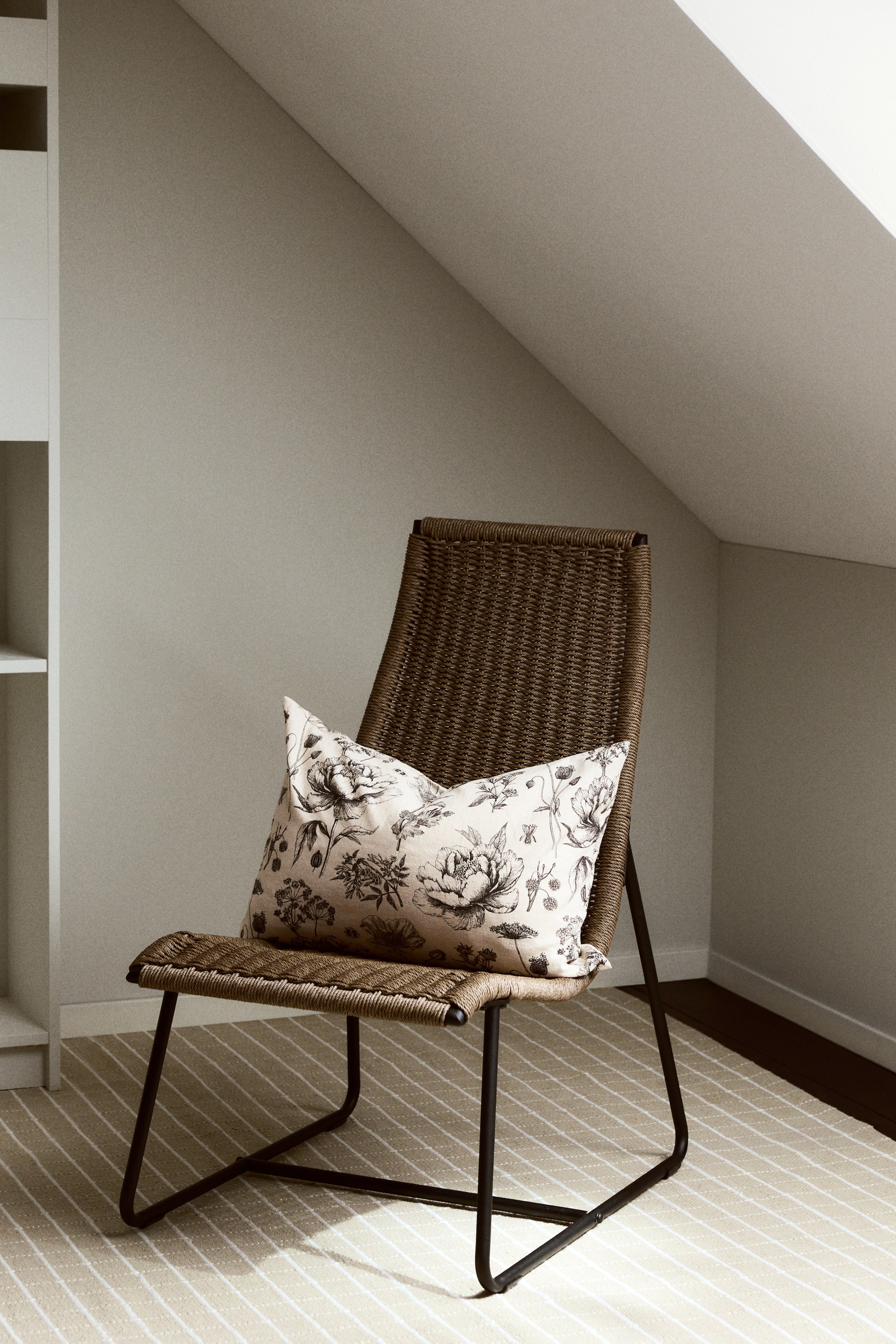 View larger image: The cushion cover showcases its front, adorned with a black and white floral pattern on a cotton-linen blend weave. It features a plump, rectangular shape with a zipper along one side.