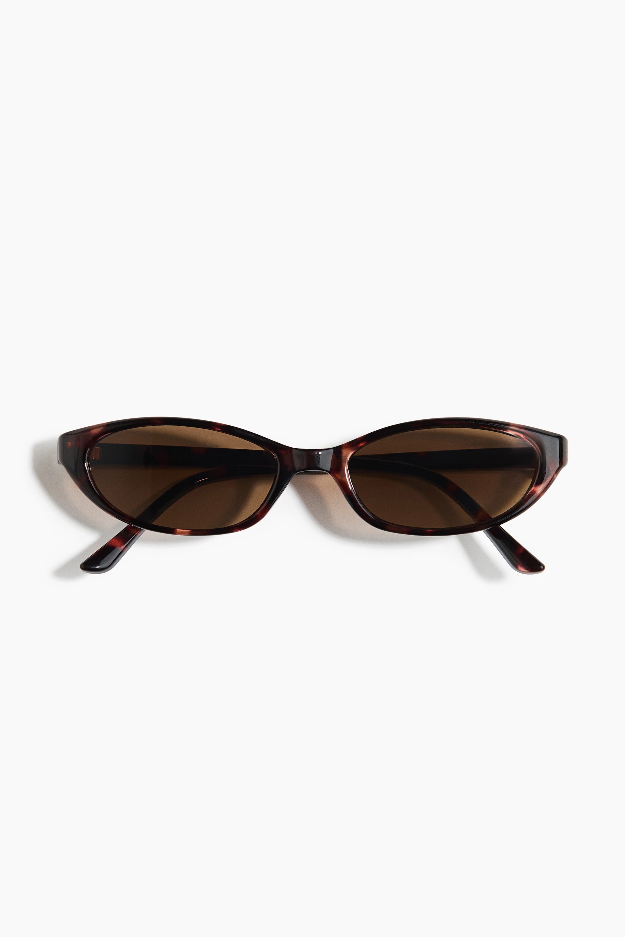 View larger image: The sunglasses are featuring a front view, showcasing tortoiseshell frames with brown, slightly oval lenses.