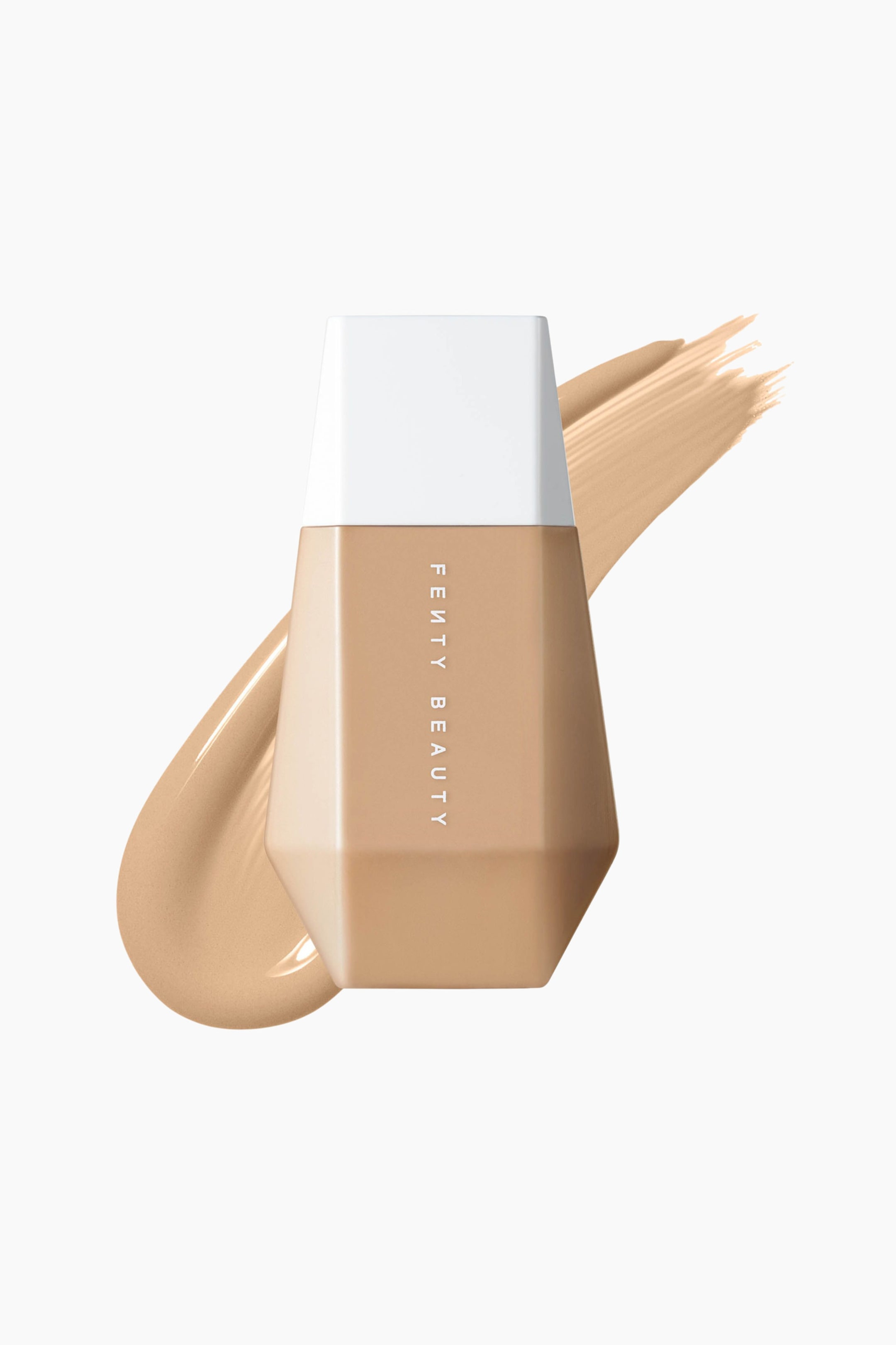 Visa större bild: En flaska Fenty Beauty Eaze Drop Blurring Skin Tint står upprätt och visar upp sin vinklade, multifacetterade design med ett vitt lock och vertikal varumärkestext. Flaskan överlappar ett diagonalt svep av den matchande beigea flytande foundationen, som visar en slät, krämig textur.