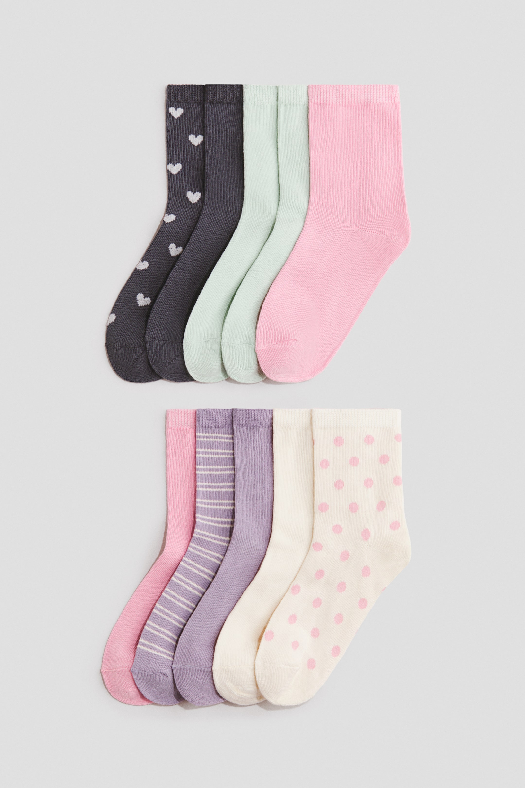 Ampliar la imagen: Calcetines de mezcla de algodón de tejido fino con puños acanalados y elásticos se muestran extendidos en dos filas, destacando una vista de perfil lateral. La selección presenta colores sólidos en rosa, verde menta, morado, crema y gris oscuro, junto con diseños de corazones, rayas horizontales y lunares.