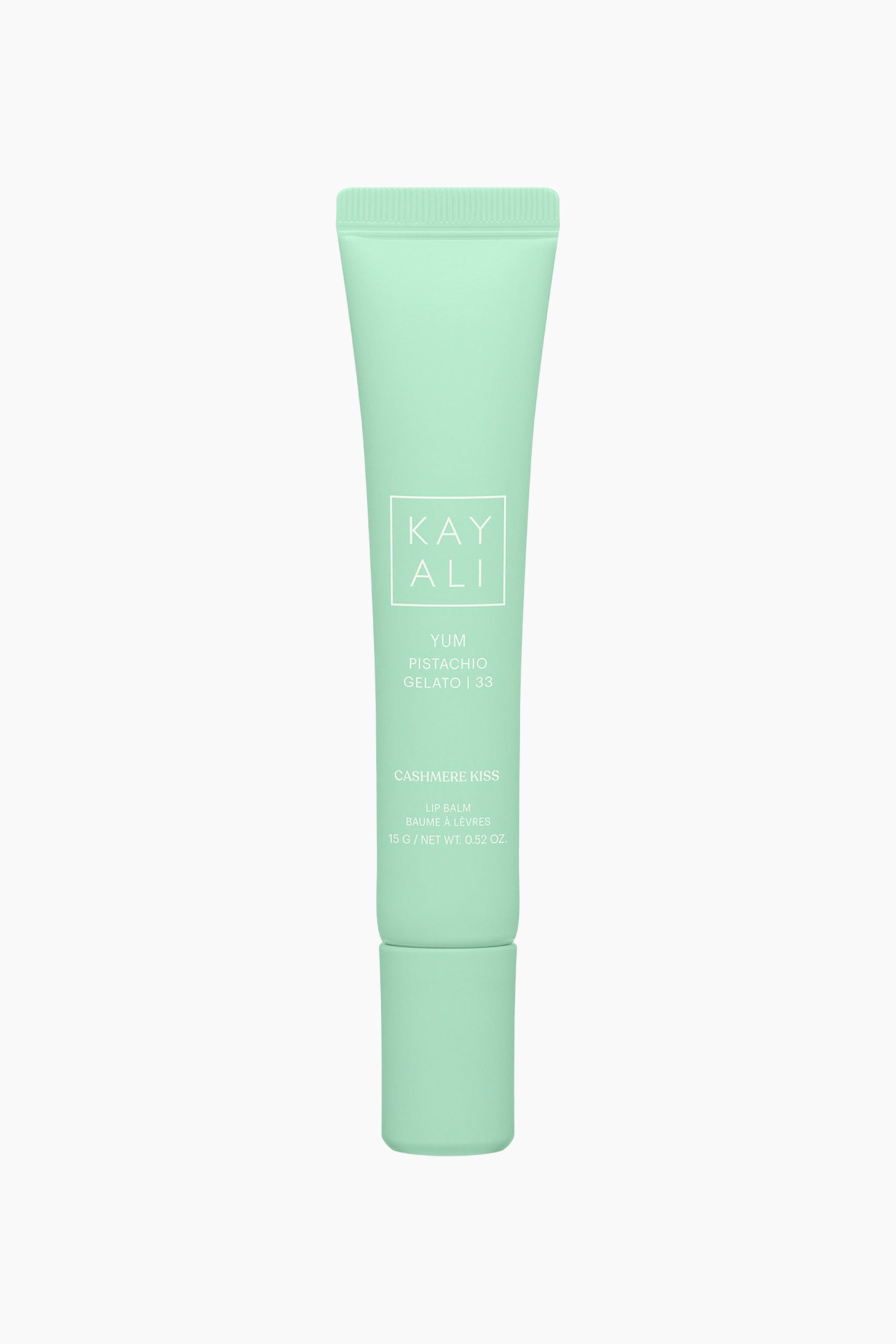 Näytä suurempi kuva: Yum Pistachio Gelato | 33 Cashmere Kiss Lip Balm seisoo pystyasennossa ja esittelee mintunvihreän puristettavan tuubin, jossa on siihen sopiva sylinterimäinen korkki. Eteenpäin suunnattu tuubi näyttää valkoista tekstiä, johon sisältyvät neliön sisällä oleva "KAYALI"-tuotenimi, "YUM PISTACHIO GELATO | 33" ja "CASHMERE KISS".