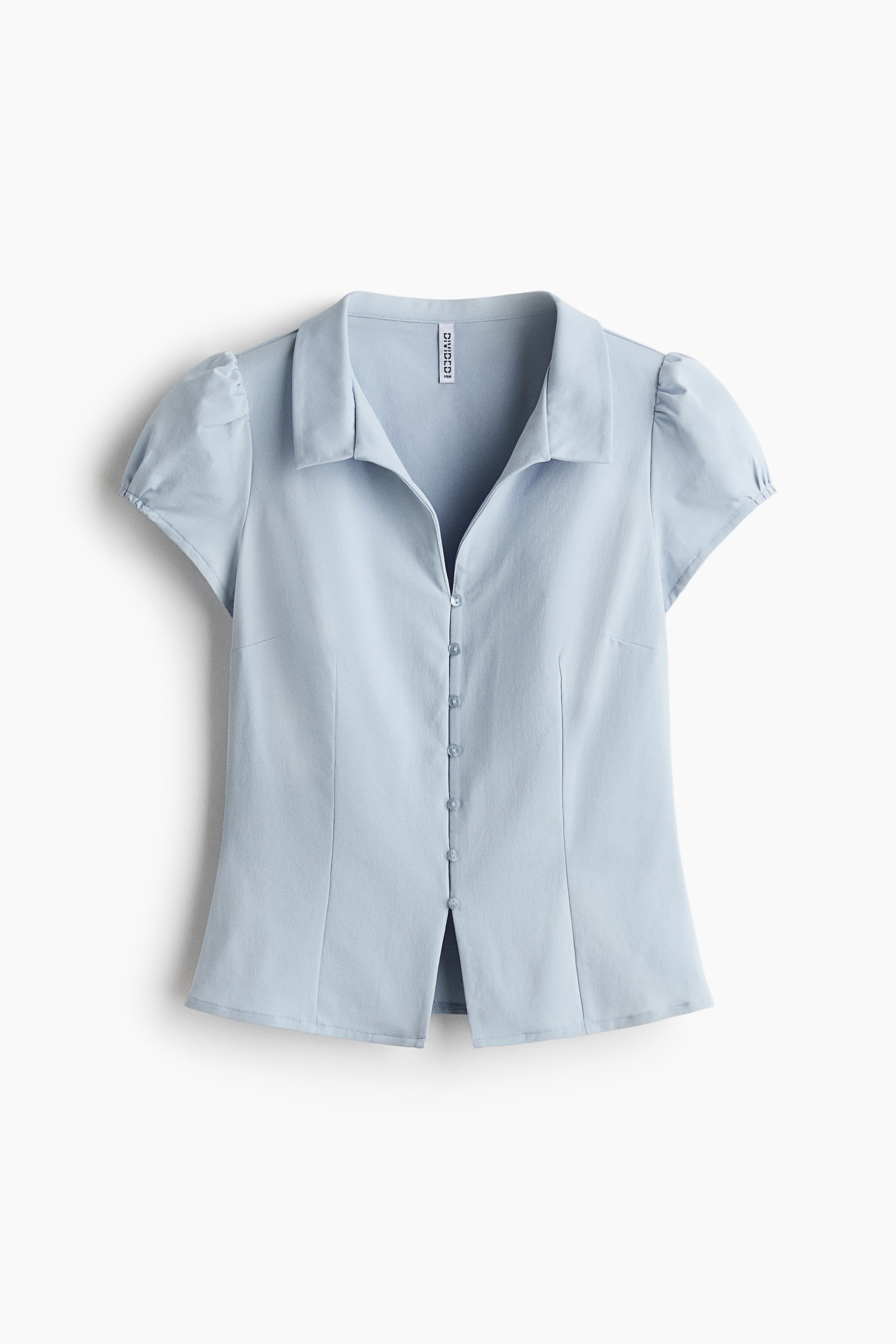 View larger image: A light blue collared button-front top is showcasing its front view. It boasts a pointed collar, short puffed sleeves, and vertical seams that contour the bodice. A complete button placket with coordinating buttons runs down the front, and the hem features a subtle front slit.