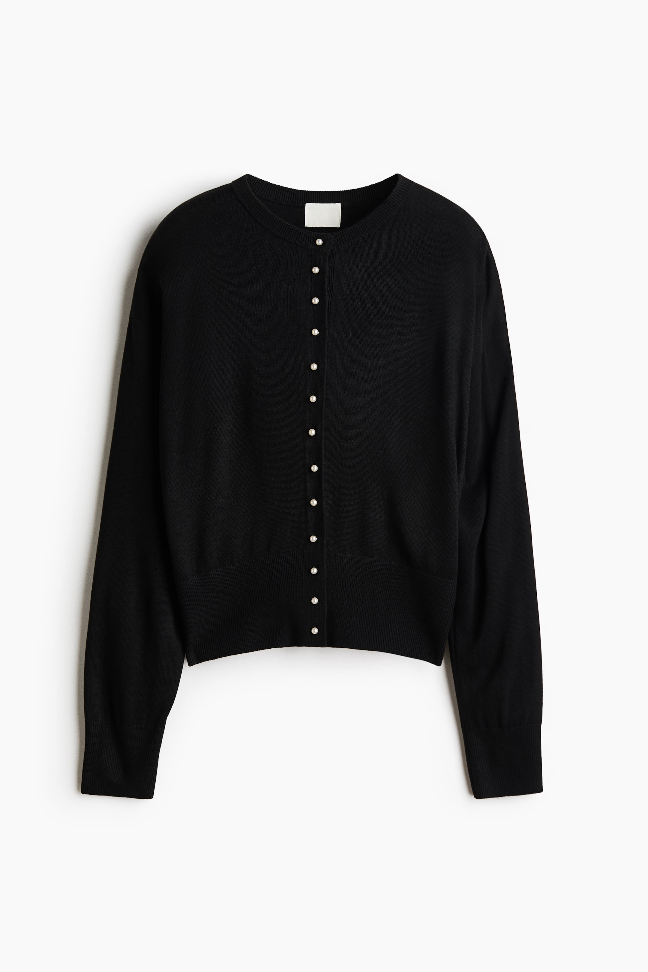 Größeres Bild ansehen: Diese schwarze Cardigan mit Rundhalsausschnitt ist frontal ausgerichtet und verfügt über eine mittige Knopfleiste mit kleinen, runden Perlmuttknöpfen. Sie zeigt ein feines Strickdesign mit langen Ärmeln, gerippten Bündchen und einem breiten gerippten Saum.