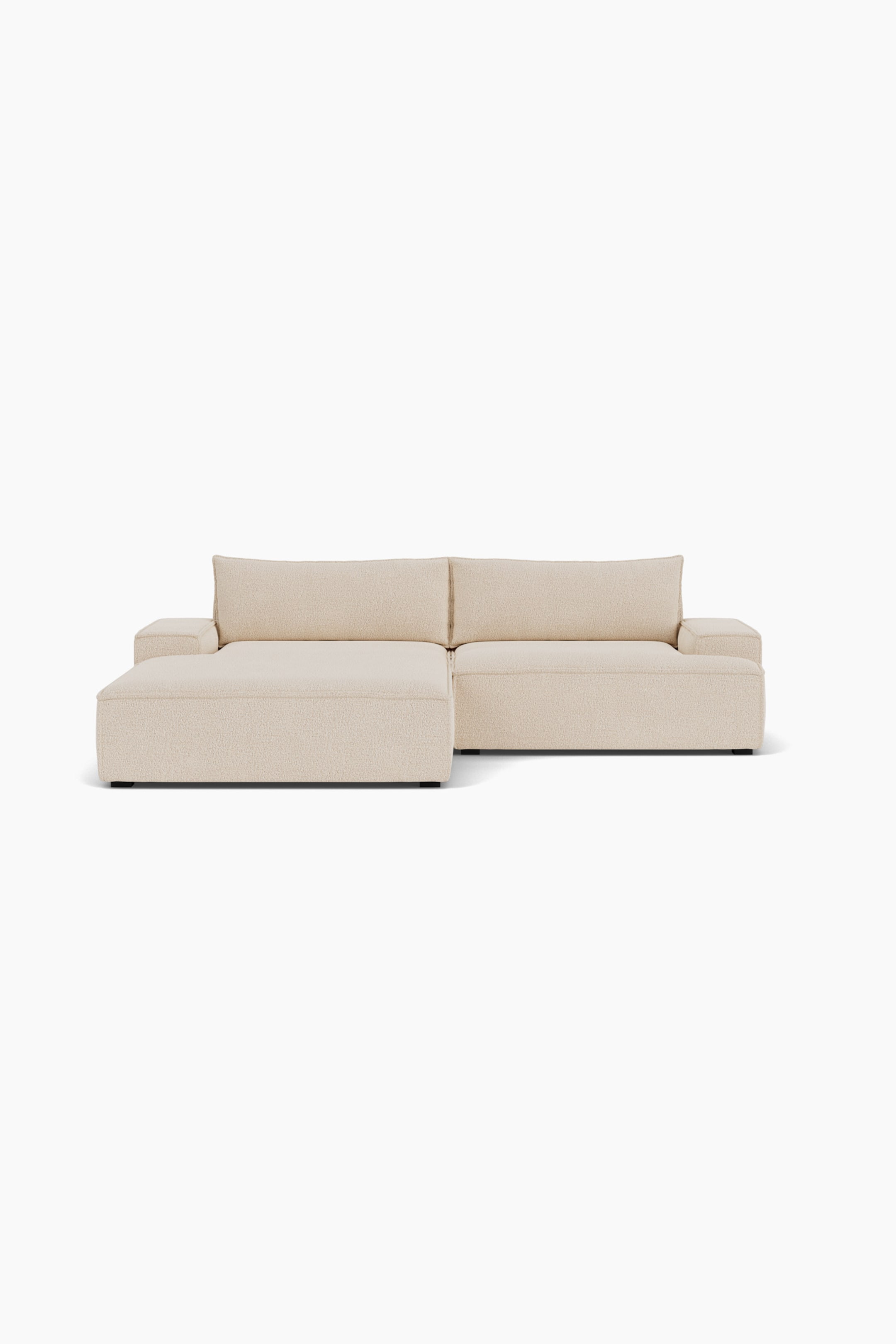 Größeres Bild ansehen: Ein hellbeiges modulares Ecksofa ist nach vorne ausgerichtet und verfügt über einen strukturierten, cremefarbenen Bezugsstoff. Das flache Design zeigt links eine breite Chaiselongue und rechts einen Standardsitz, beide eingerahmt von dicken, kantigen Armlehnen und weichen Rückenkissen.