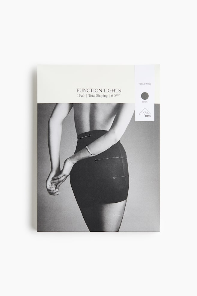 A front view of the packaging for "Function Tights" showing an off-white paper sleeve featuring a black-and-white photograph of a model from behind wearing high-waisted black shaping tights. The packaging displays text reading "FUNCTION TIGHTS", "1 Pair \| Total Shaping \| 60 DEN", alongside a vertical white label on the right indicating the colour black and featuring the "LYCRA ADAPTIV" logo. - 1