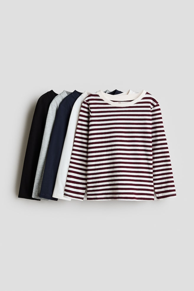 Five long-sleeved cotton jersey tops are overlapping and facing front, showcasing a burgundy and white horizontally striped top at the forefront. The remaining solid-coloured tops layered behind are in white, navy blue, heather grey and black, all featuring a round neckline with a narrow trim. - 1