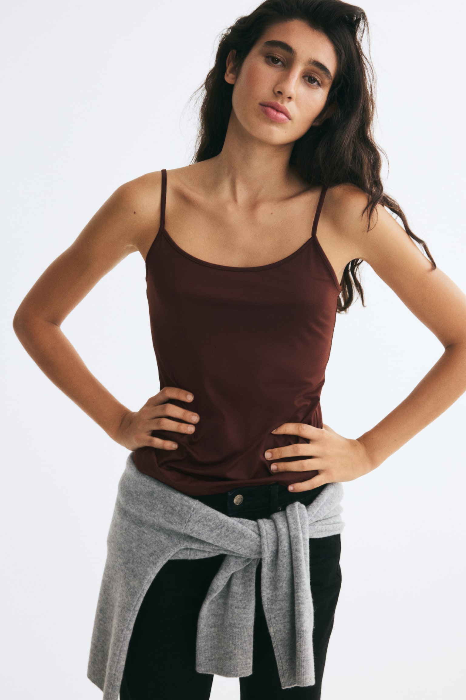 A fitted strappy top in soft dark brown microfibre is showcasing its front, featuring thin spaghetti straps and a rounded neckline. - 1