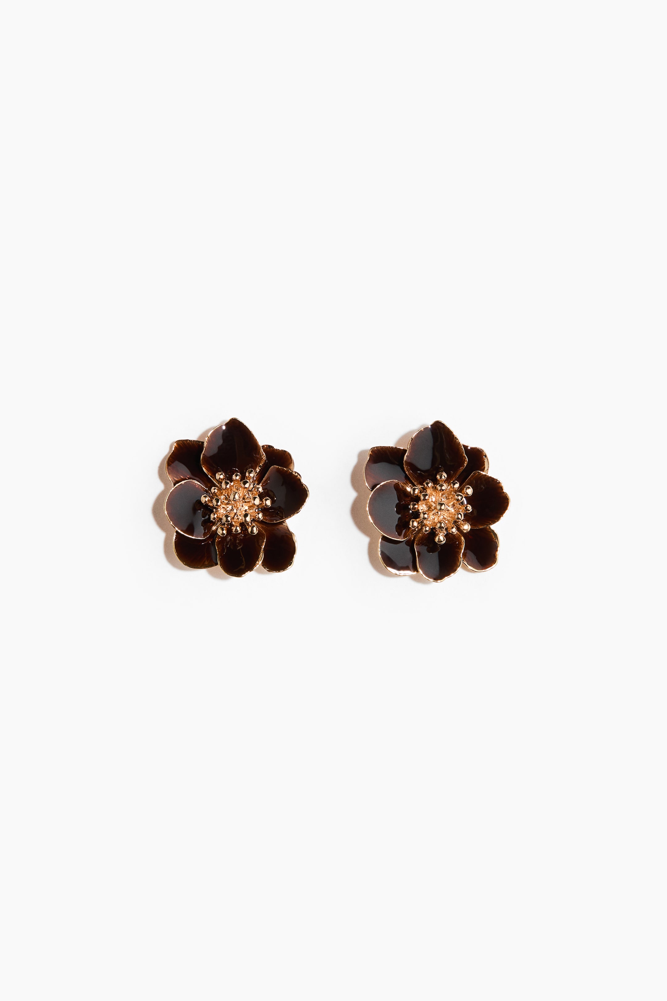 View larger image: A pair of flower-shaped stud earrings lies flat, each earring featuring dark brown glossy petals with gold-colored edges and a textured gold-colored center.
