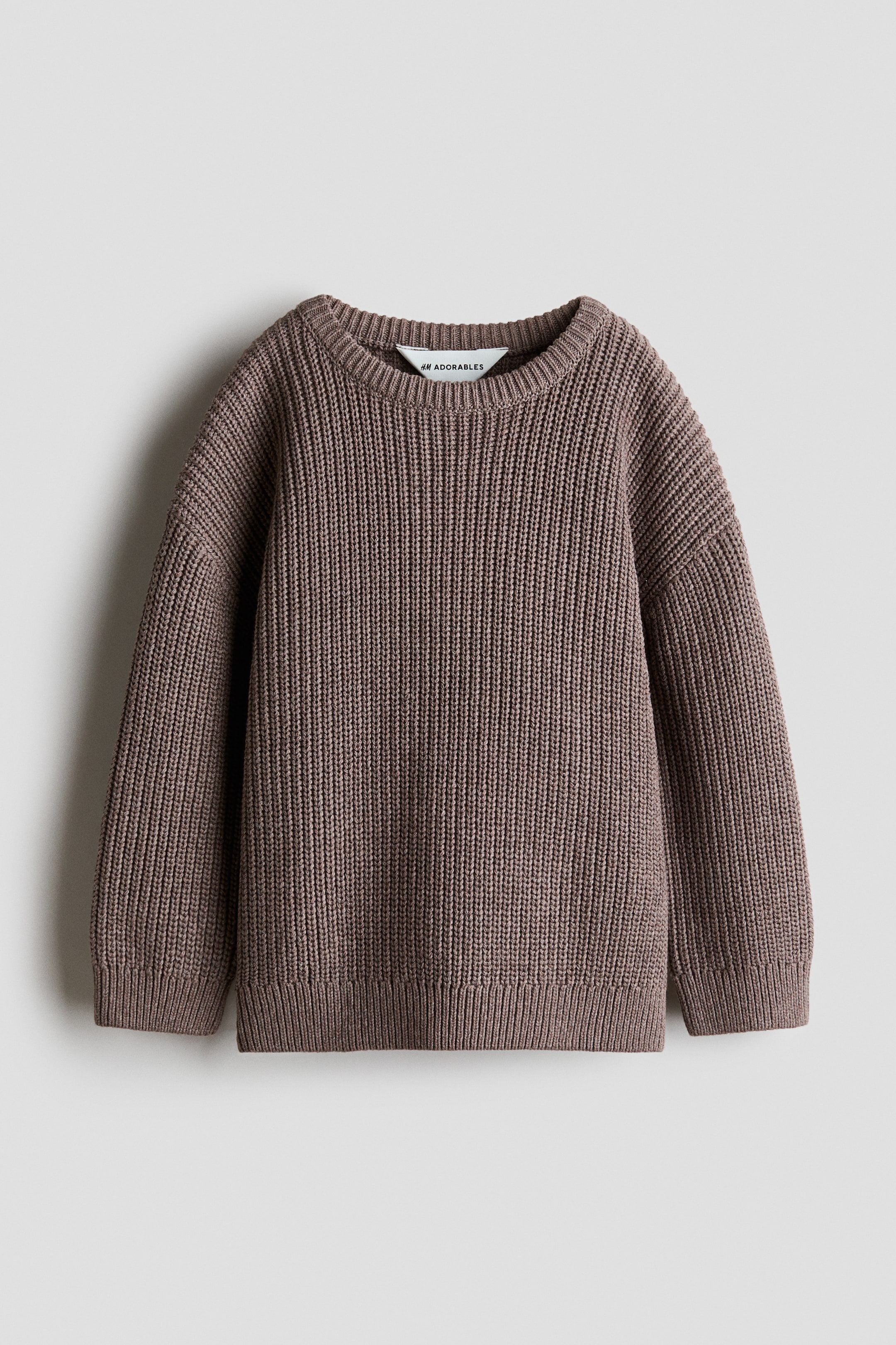 View larger image: An H&M Adorables oversized sweater is shown from the front. It features a chunky ribbed knit in a muted brown tone, a round rib-trimmed neckline, dropped shoulders, long sleeves, and ribbed cuffs and hem.