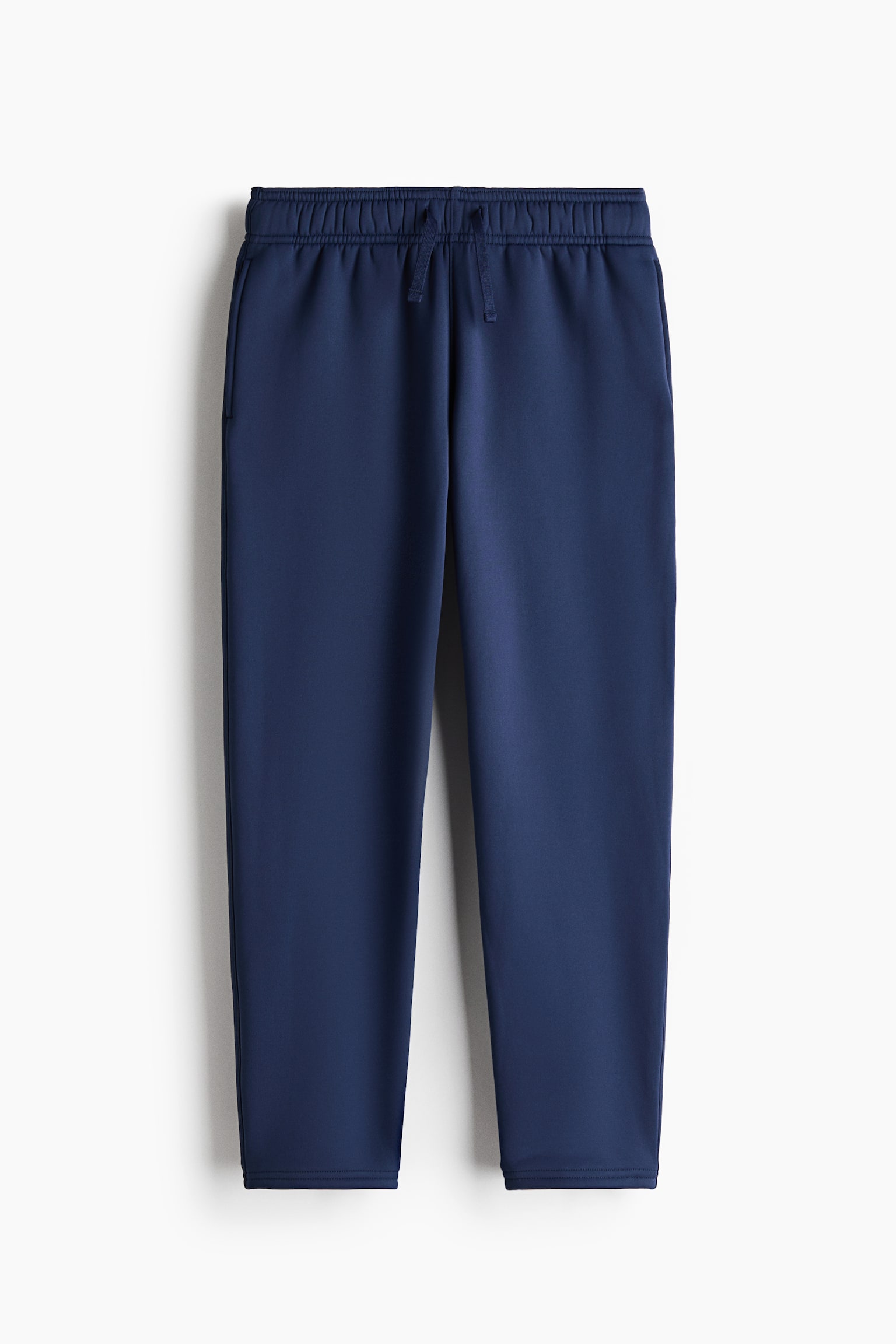 Navy blue sweatpants are shown from the front, featuring an elasticated waistband with a matching drawstring. The trousers have a straight-leg design with subtle side pockets and clean-finished hems. - 1