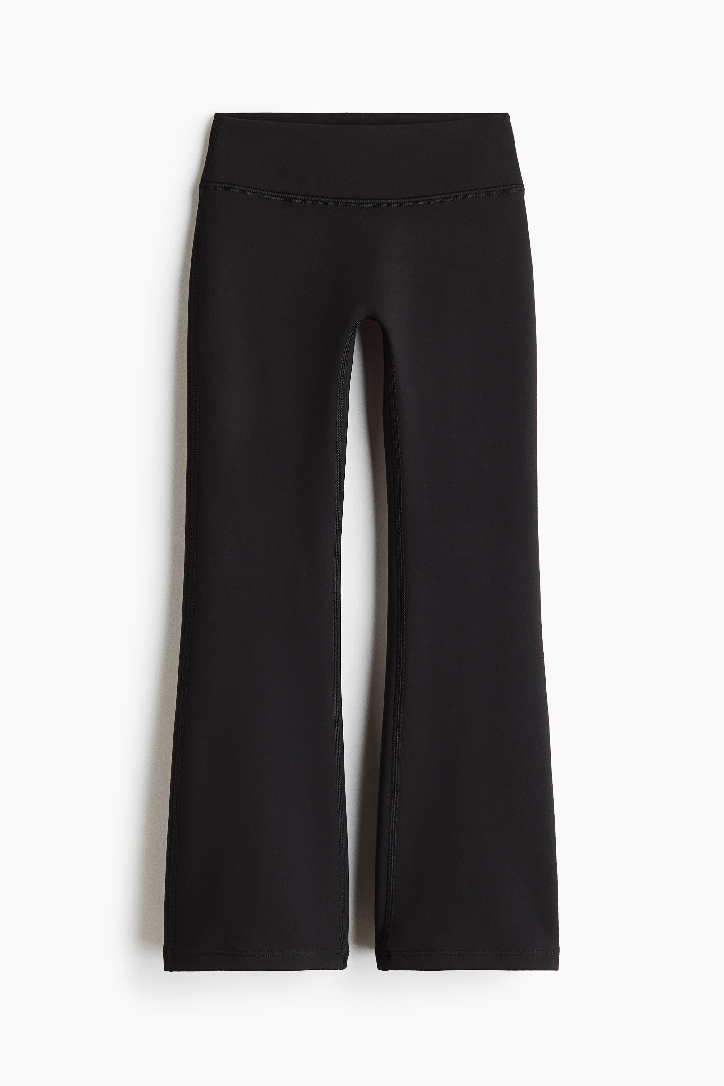 Un ensemble noir assorti en deux piÃ¨ces est prÃ©sentÃ© de face, comprenant un haut Ã  col rond Ã  manches longues avec manches raglan et poignets cÃ´telÃ©s. Le pantalon coordonnÃ© est ajustÃ© au niveau des cuisses puis sâÃ©vase vers les chevilles.