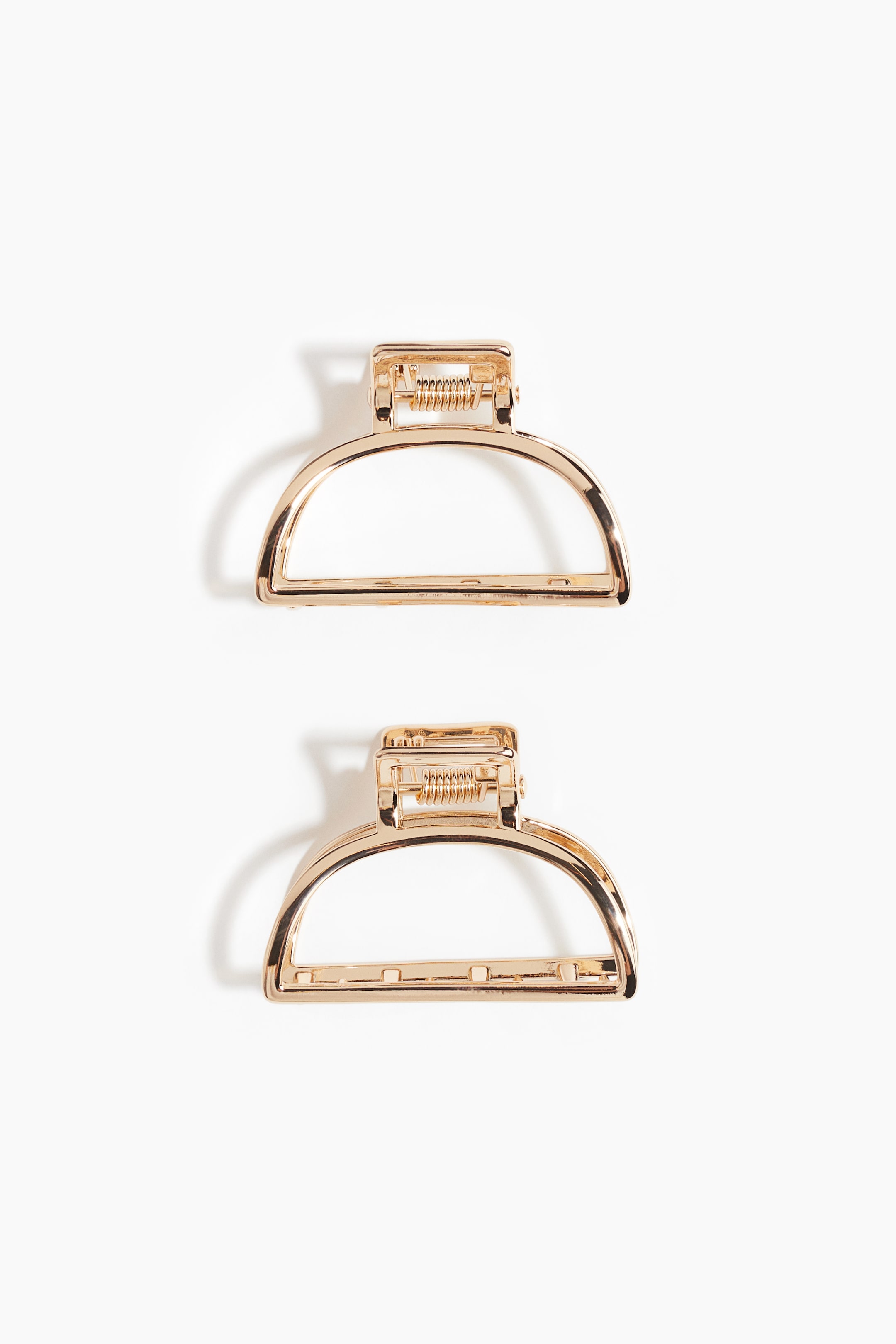 View larger image: Two shiny metal hair claws are being presented, each featuring a D-shaped design with a rectangular top section housing a visible spring mechanism, viewed from the front.