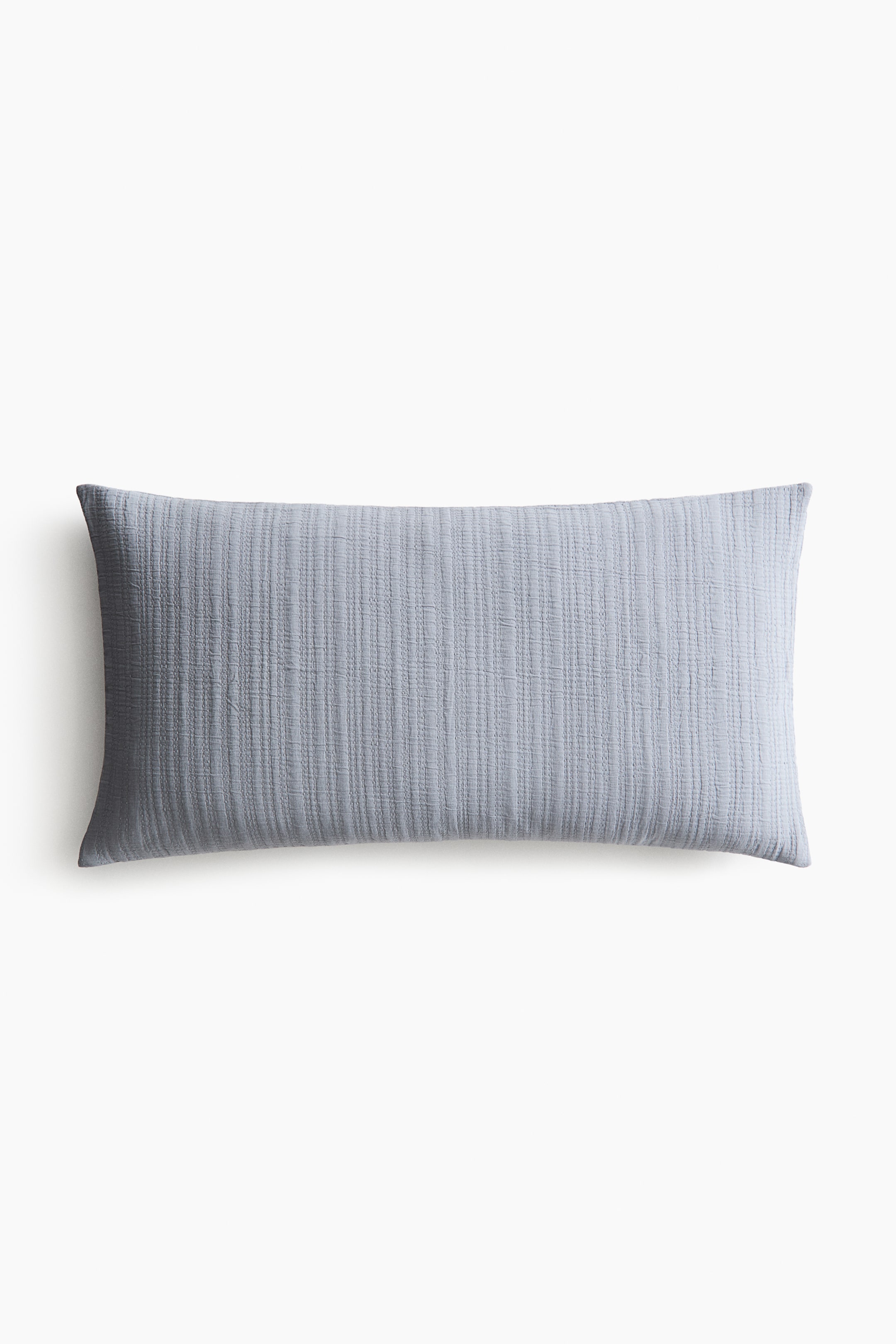 View larger image: A rectangular cushion cover is showcasing its front, featuring a light blue-grey, soft, crinkled cotton weave. The fabric is detailed with stitching that adds texture.