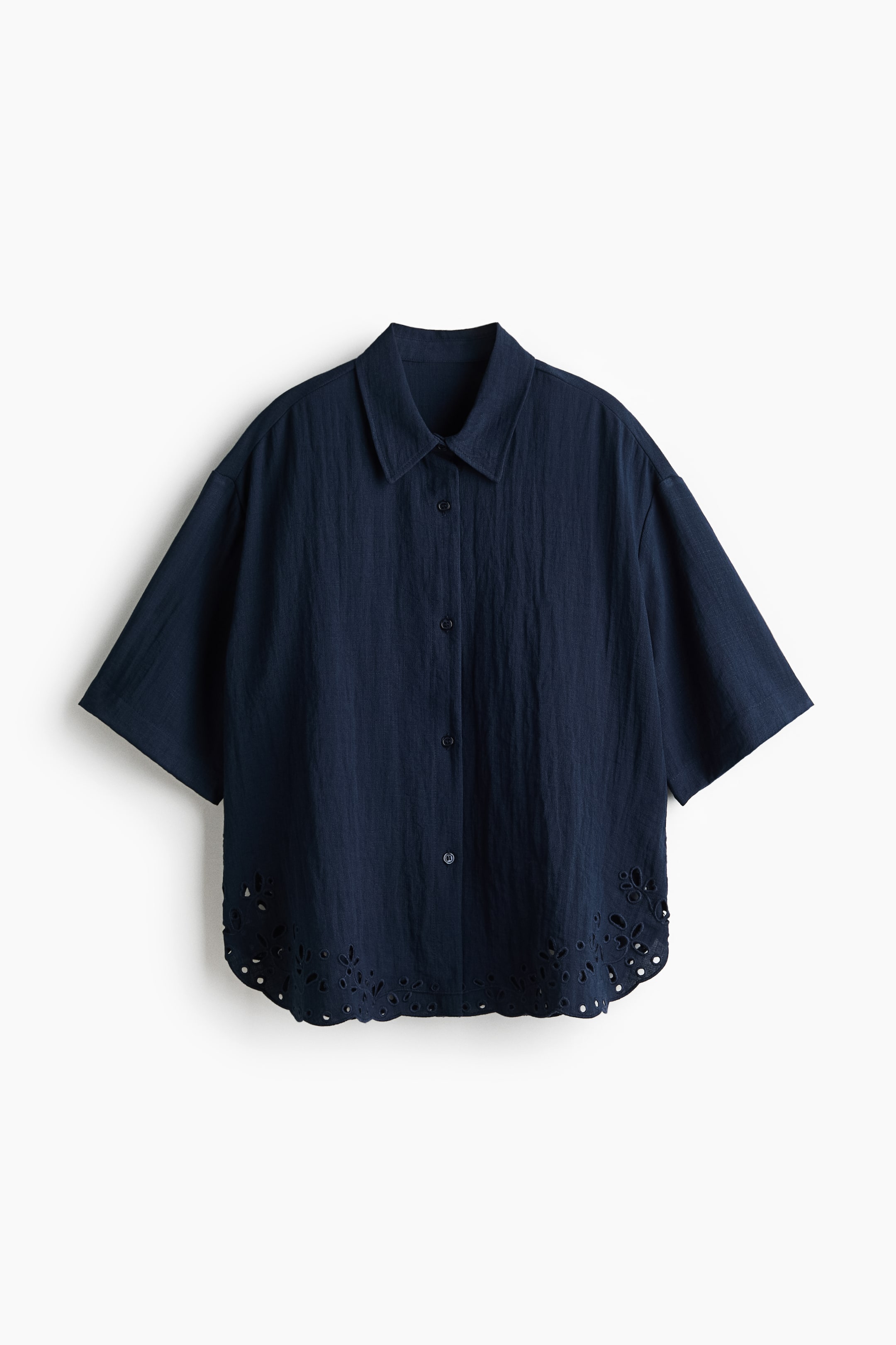 Agrandir l'image: Une chemise de plage bleu marine à coupe ample en tissu tissé est présentée de face, avec un col, des boutons sur le devant, des épaules tombantes et des manches longueur coude. Son ourlet arrondi est orné de broderie anglaise.