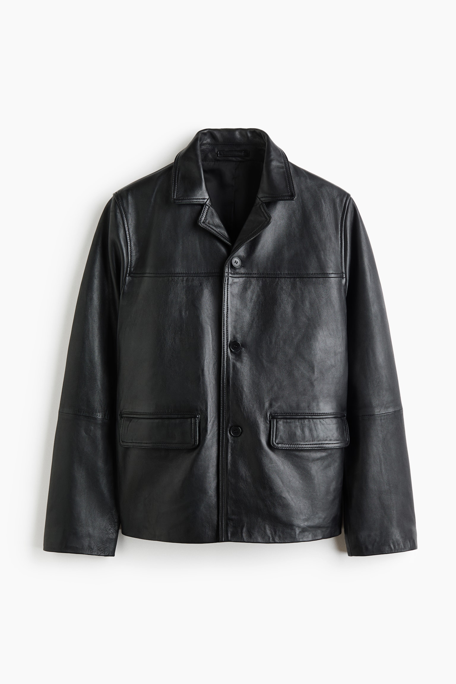A black single-breasted leather jacket is shown facing forward, showcasing a classic regular-fit silhouette with notch lapels and a three-button front fastening. The jacket features a horizontal chest yoke, two front flap pockets, and a straight-cut hem.