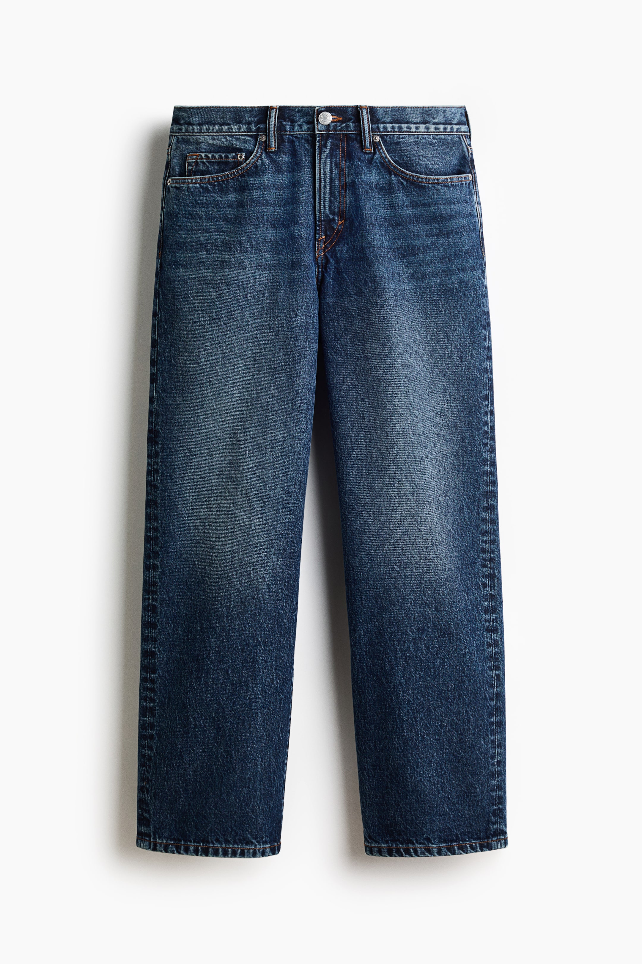 Agrandir l'image: Jean bleu foncé à 5 poches présenté de face, avec une taille régulière, une fermeture à glissière et bouton, et des surpiqûres contrastantes orange. Le denim en coton rigide présente une coupe droite, une coupe décontractée des hanches à l'ourlet, et un délavage visible sur les cuisses.