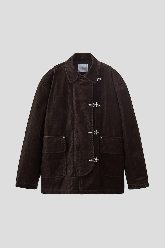 A dark brown corduroy jacket is presented from the front. It features a point collar, four silver-toned toggle closures on the central placket, and two large patch pockets on the lower front. - 1